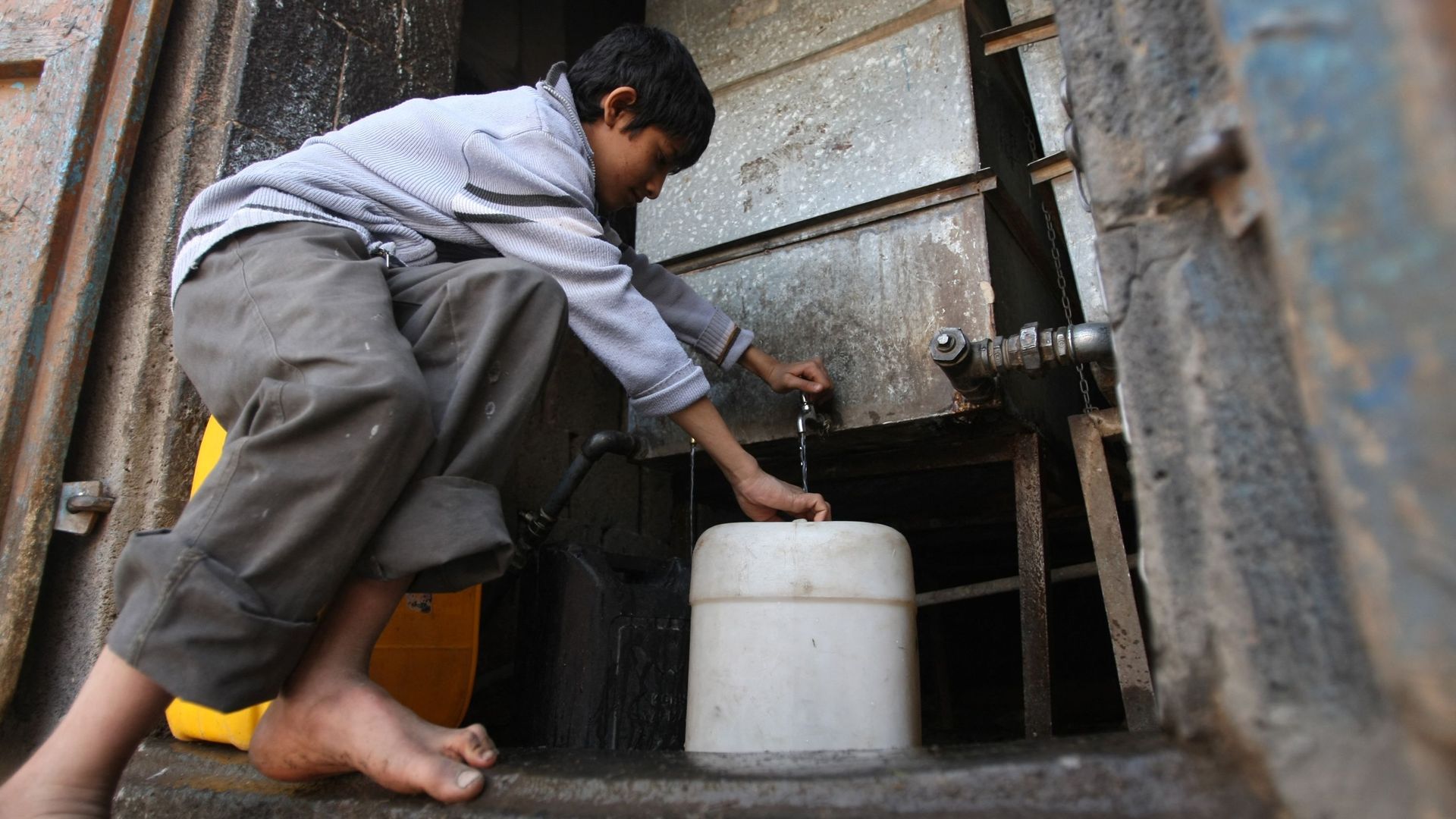 Un jeune Yéménite remplit des récipients d’eau à un robinet public à Sanaa, le 15 janvier 2012, alors que le pays est confronté à une pénurie d’eau et de carburant dans un contexte de violences et de manifestations contre le régime.
