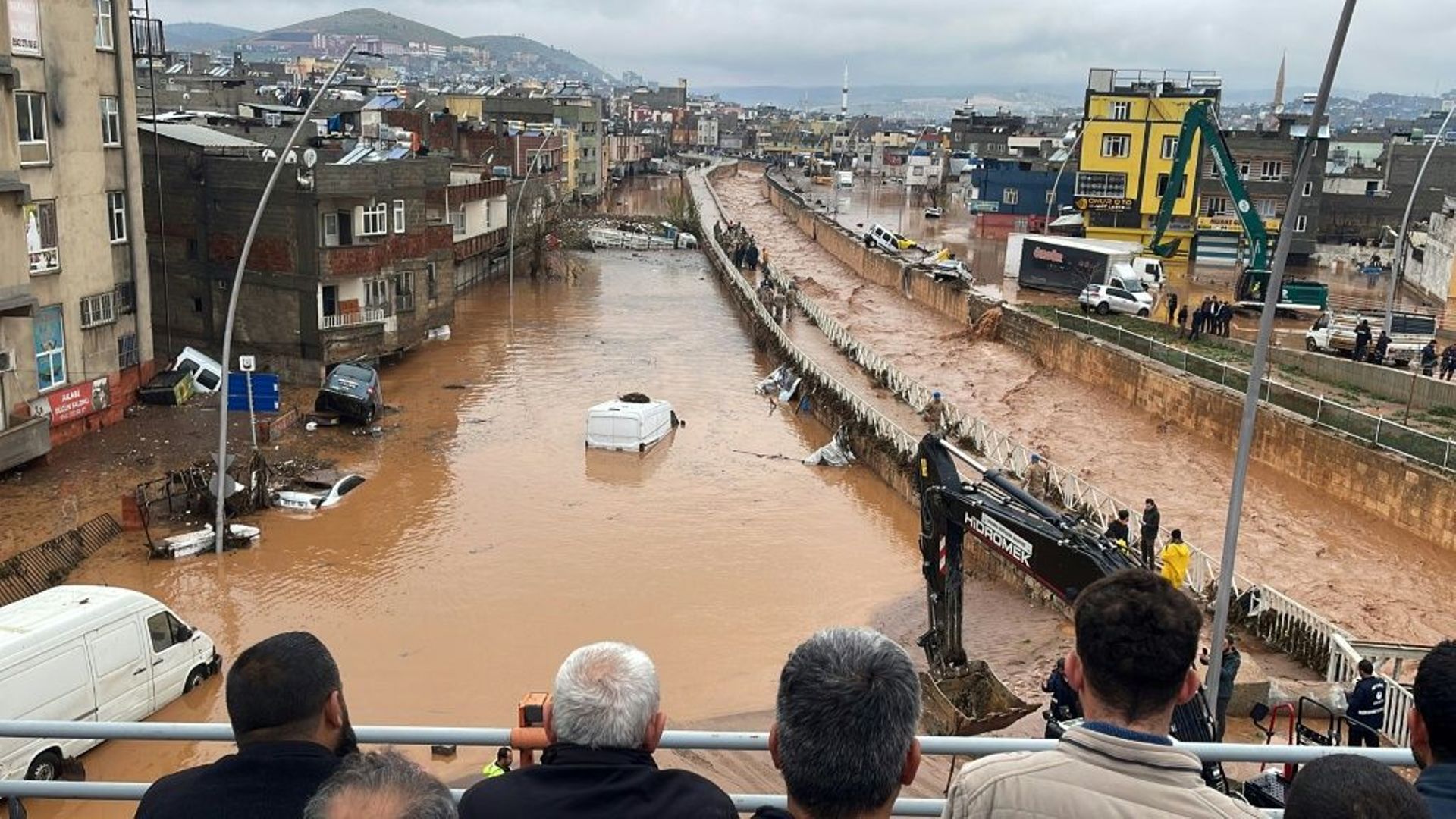 Des habitants contemplent depuis un pont les dégâts provoqués par des pluies torrentielles à Sanliurfa, grande ville turque proche de la frontière syrienne, le 15 mars 2023