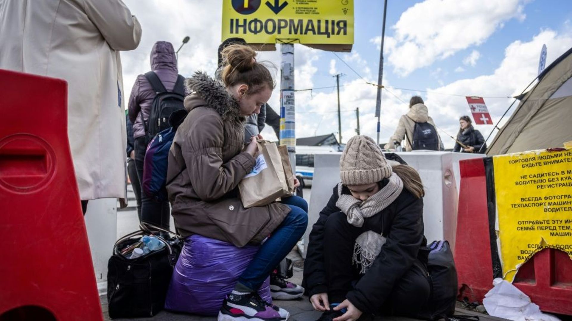 Des jeunes réfugiées ukrainiennes attendent un bus après avoir franchi la frontière avec la Pologne, le 8 avril 2022 à Medyka