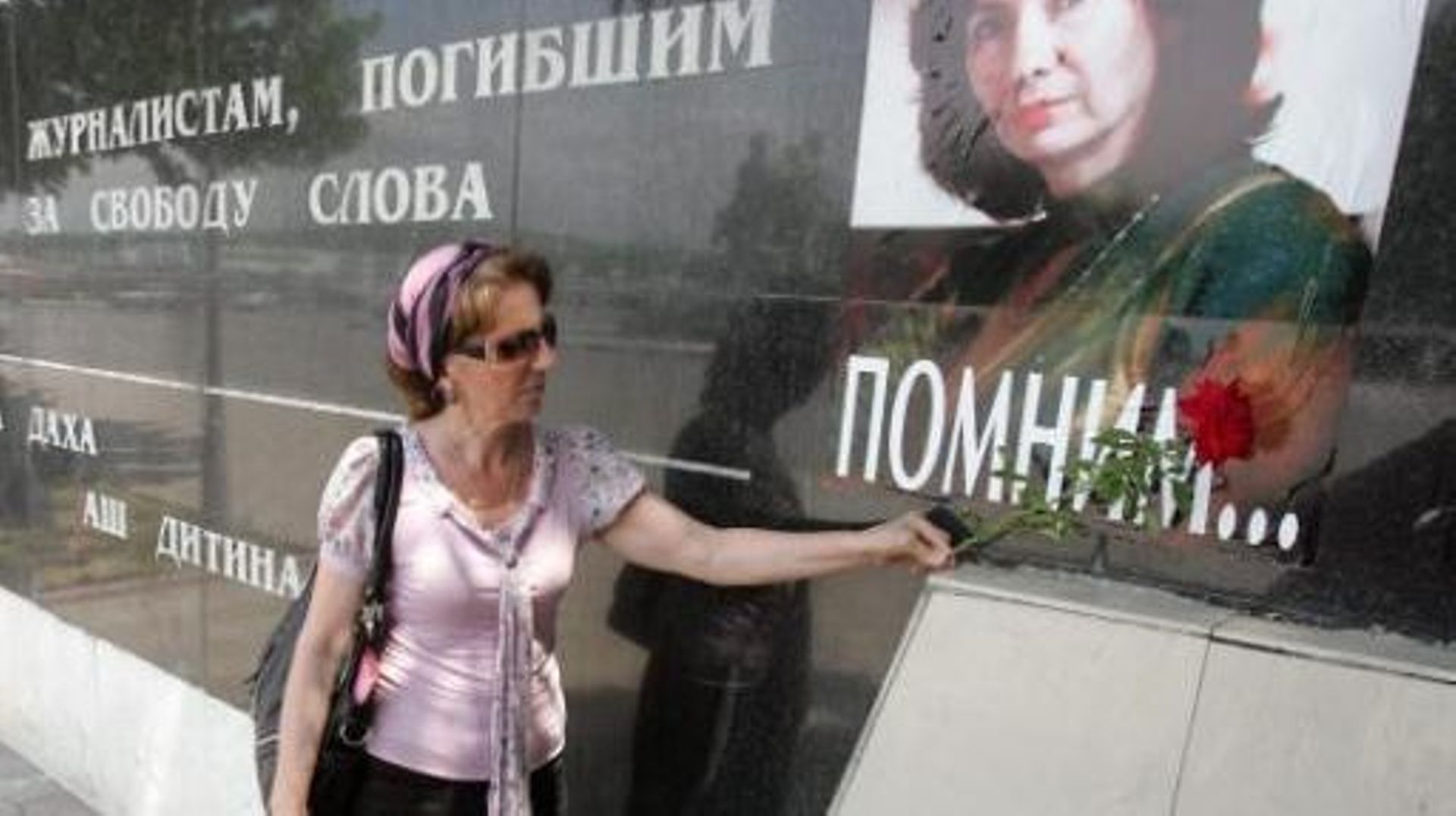 Une Tchétchène fleurit un portarit de Natalia Estemirova, journaliste assassinée en 2009 qui travaillait pour l'ONG Memorial