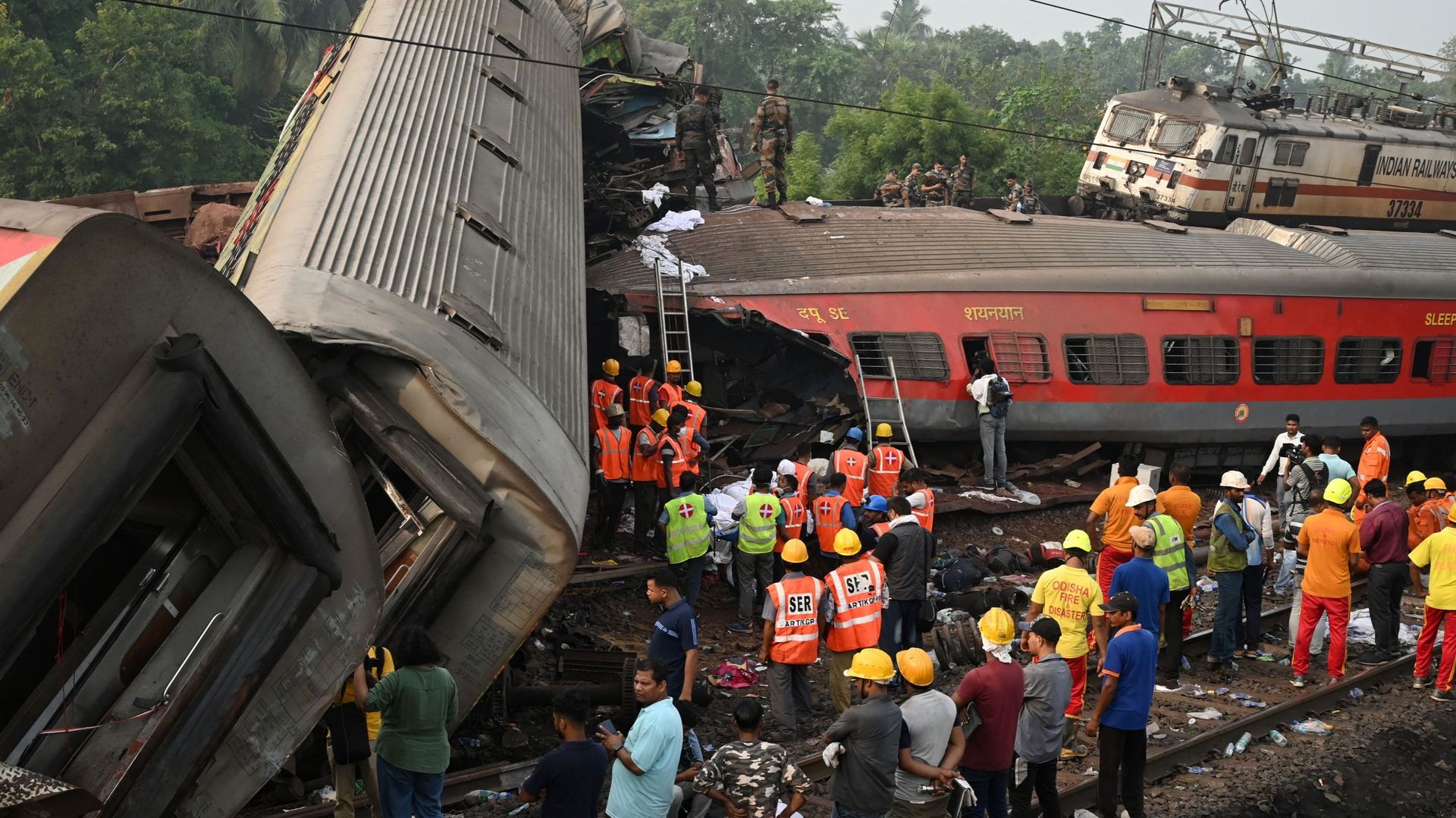 Des secouristes se rassemblent autour des wagons endommagés sur le site d'une collision entre trois trains près de Balasore, à environ 200 km de la capitale Bhubaneswar, dans l'État d'Odisha, le 3 juin 2023.