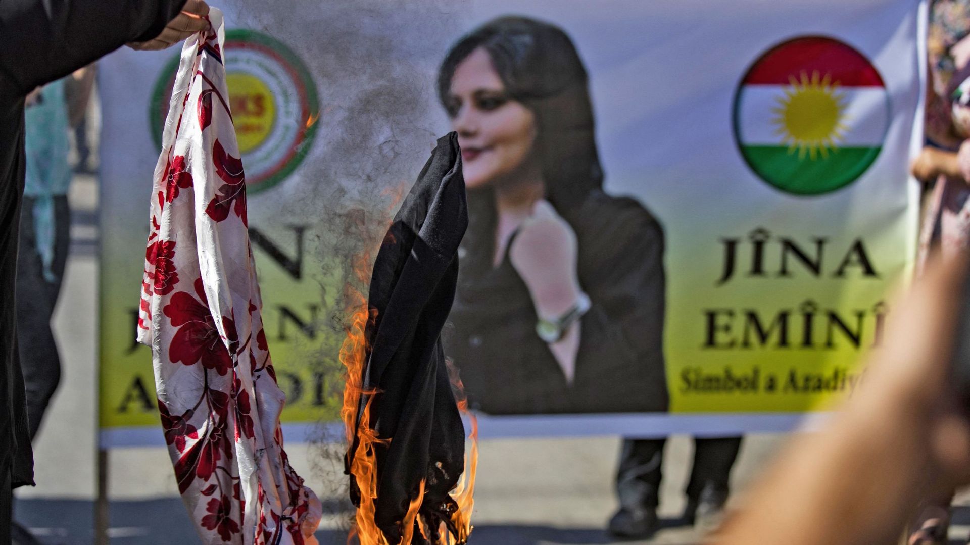 Des manifestants brûlent des foulards lors d’une manifestation de solidarité organisée par le bloc politique syro-kurde "Conseil national kurde", contre la mort de Mahsa Amini (bannière), 22 ans, une Iranienne décédée alors qu’elle était détenue par les a