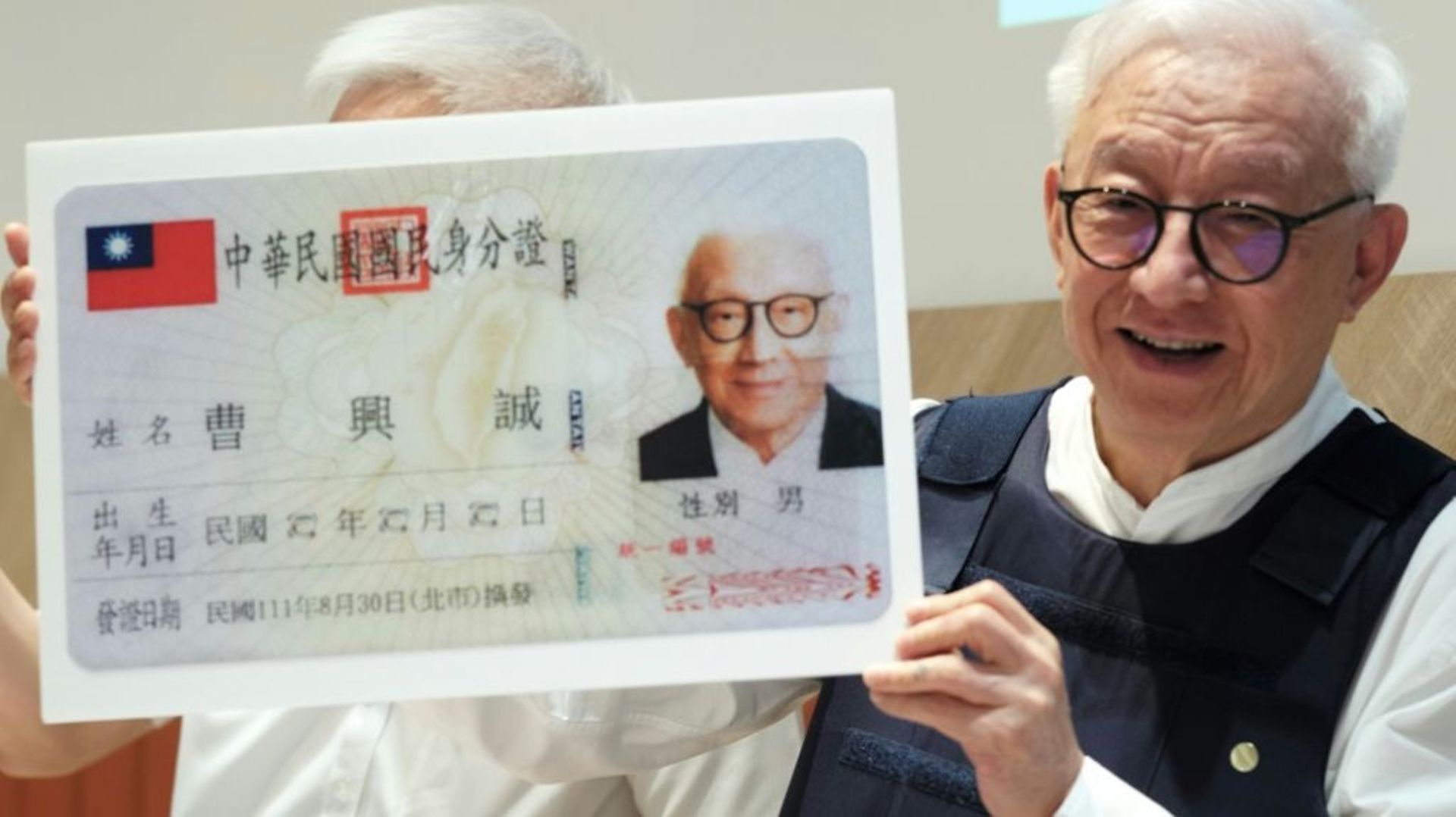 L’homme d’affaires Robert Tsao, portant un gilet pare-balles, présente une copie agrandie de sa carte d’identité lors d’une conférence de presse au Parlement à Taipei (Taïwan), le 1er septembre 2022