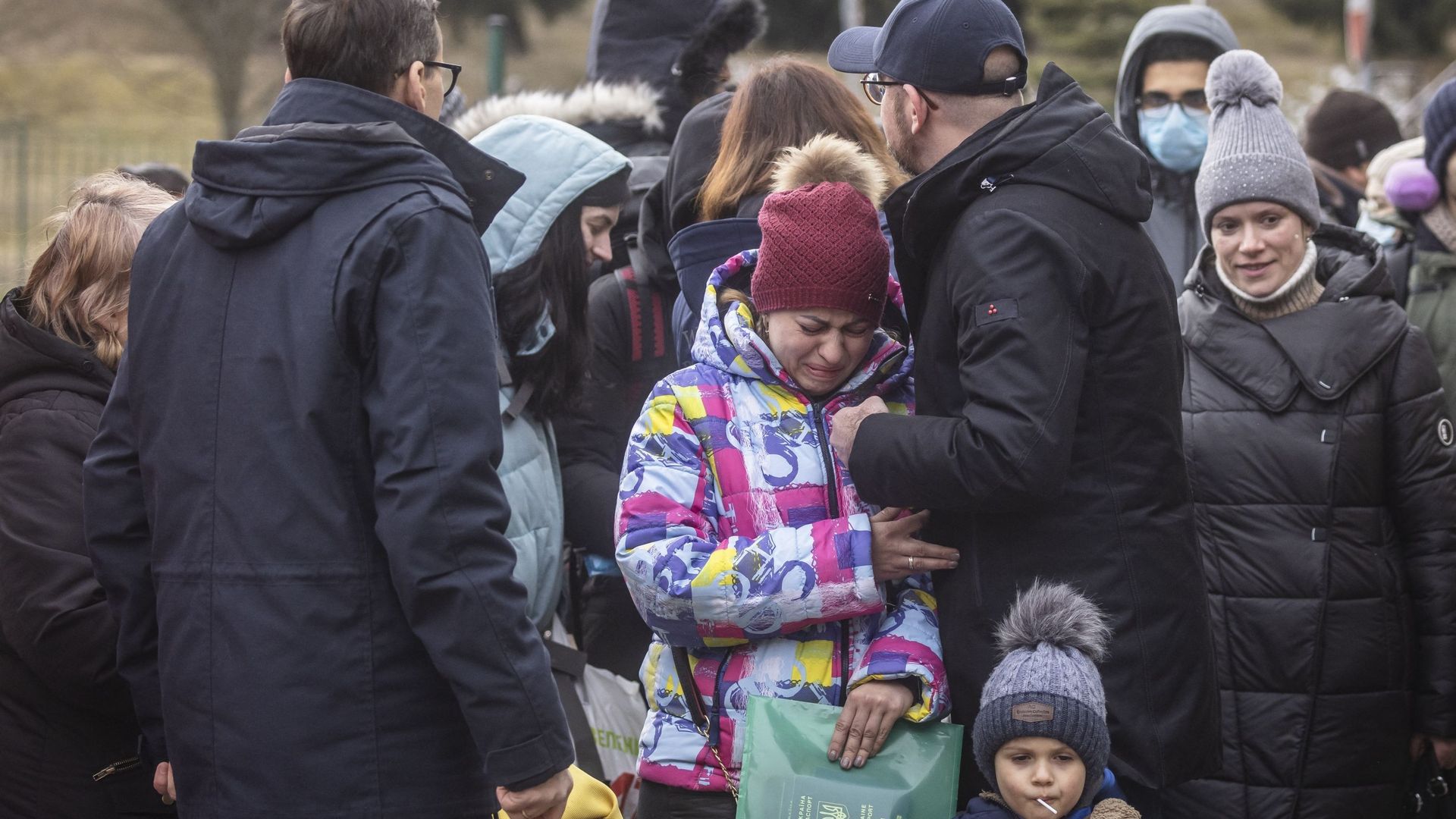Le président du Conseil européen Charles Michel et le Premier ministre polonais Mateusz Morawiecki réconfortent une Ukrainienne arrivant à la frontière, à Korczowa le 2 mars 2022.
