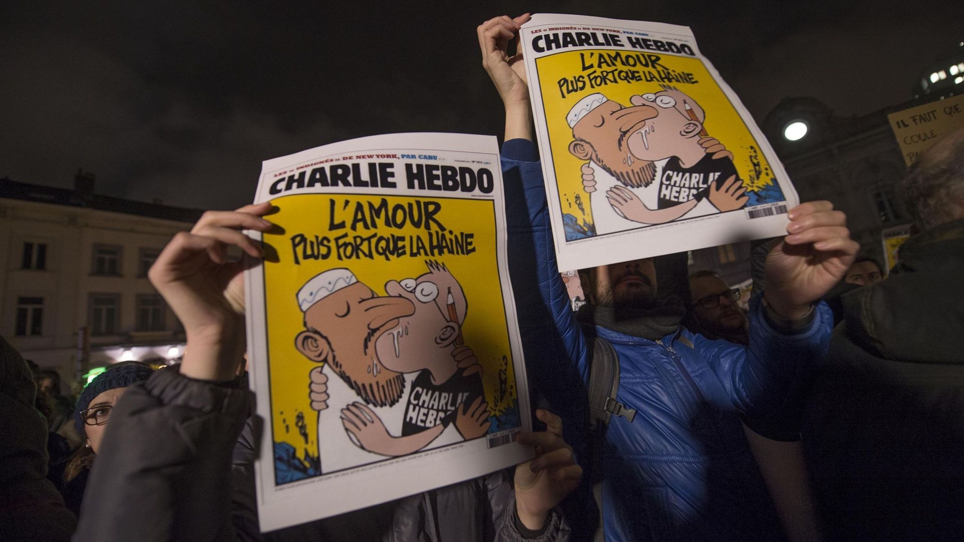 Des personnes présentent un numéro de Charlie Hebdo en 2015