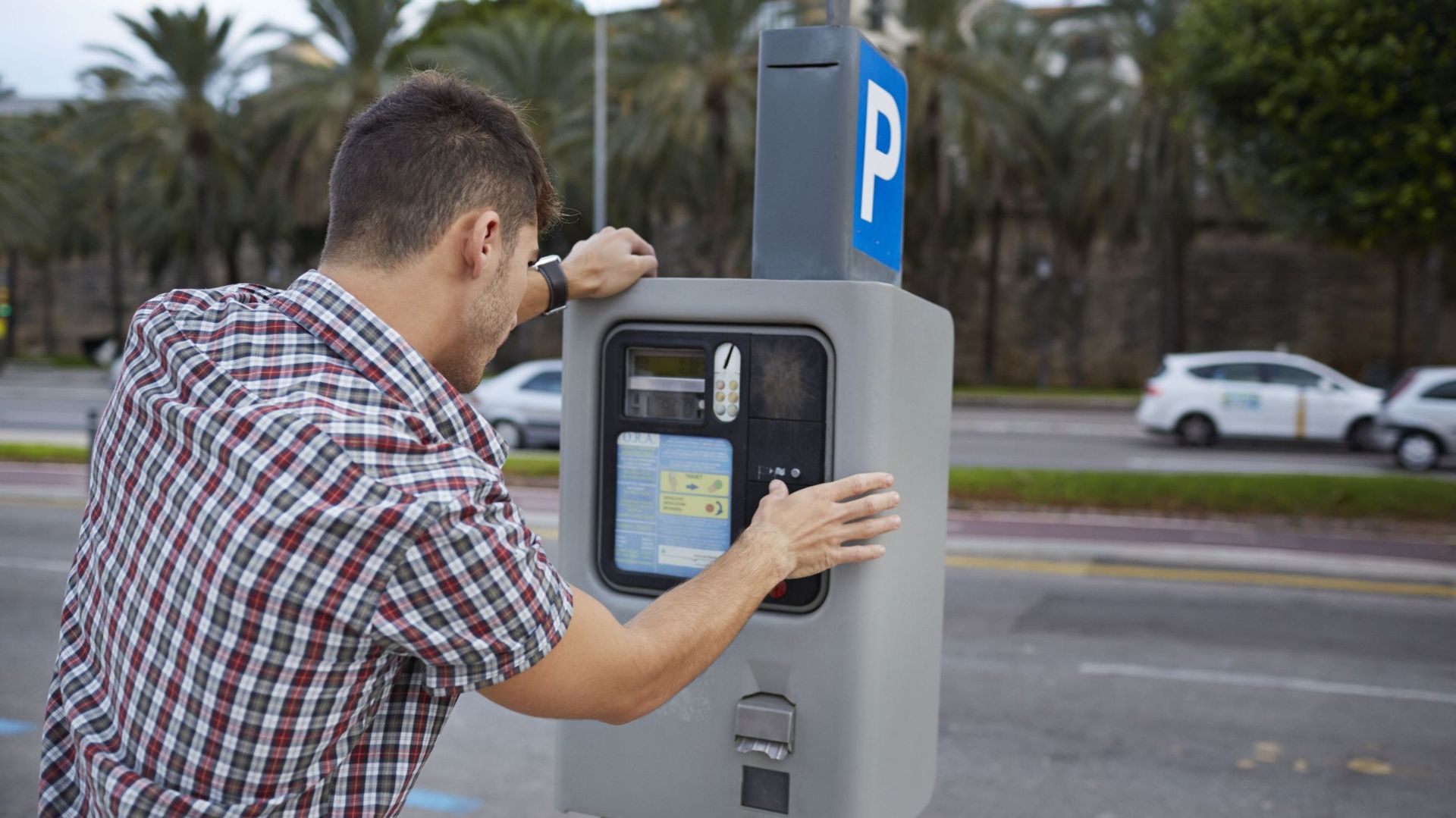 Man feeding parking meter.