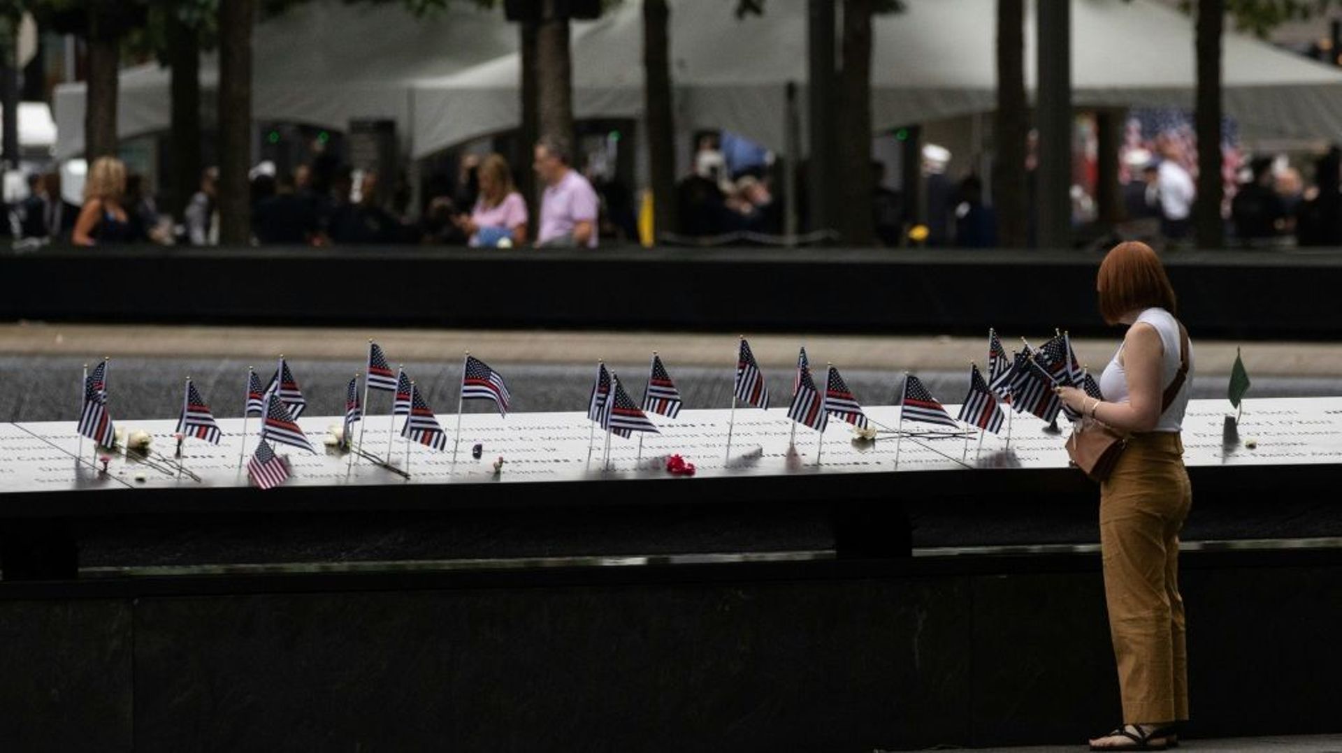 Une personne place un drapeau américain sur le mémorial pour les victimes du 11-Septembre à New York, le 11 septembre 2022.