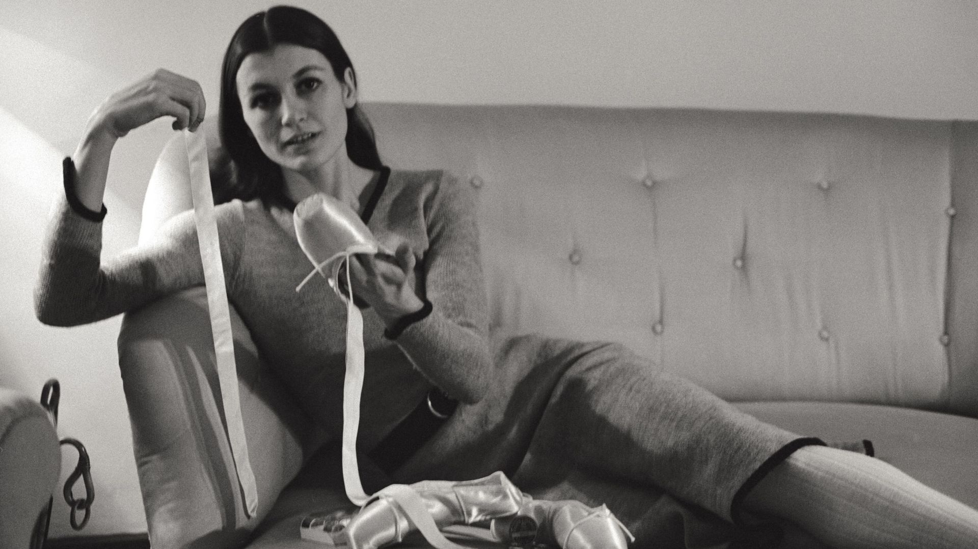 Portrait de la danseuse de ballet Carla Fracci, interviewée dans sa maison alors qu’elle coud, appliquant des rubans de soie sur ses chaussons de danse. Milan, février 1969.
