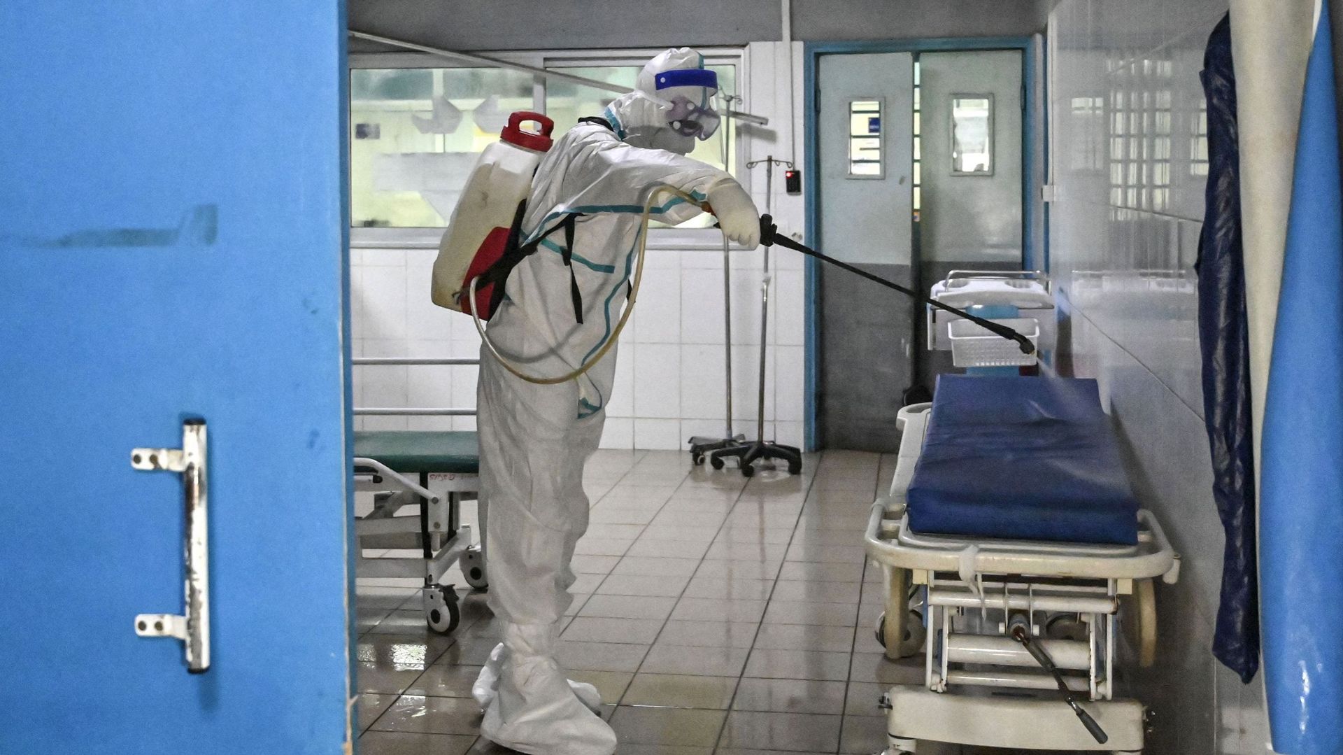 Un agent de l'Institut national d'hygiène publique (INHP) portant une combinaison d'équipement de protection individuelle (EPI) contre le virus Ebola désinfecte les locaux du CHU de Cocody suite au passage d'un premier patient Ebola, à Cocody le 16 août 2