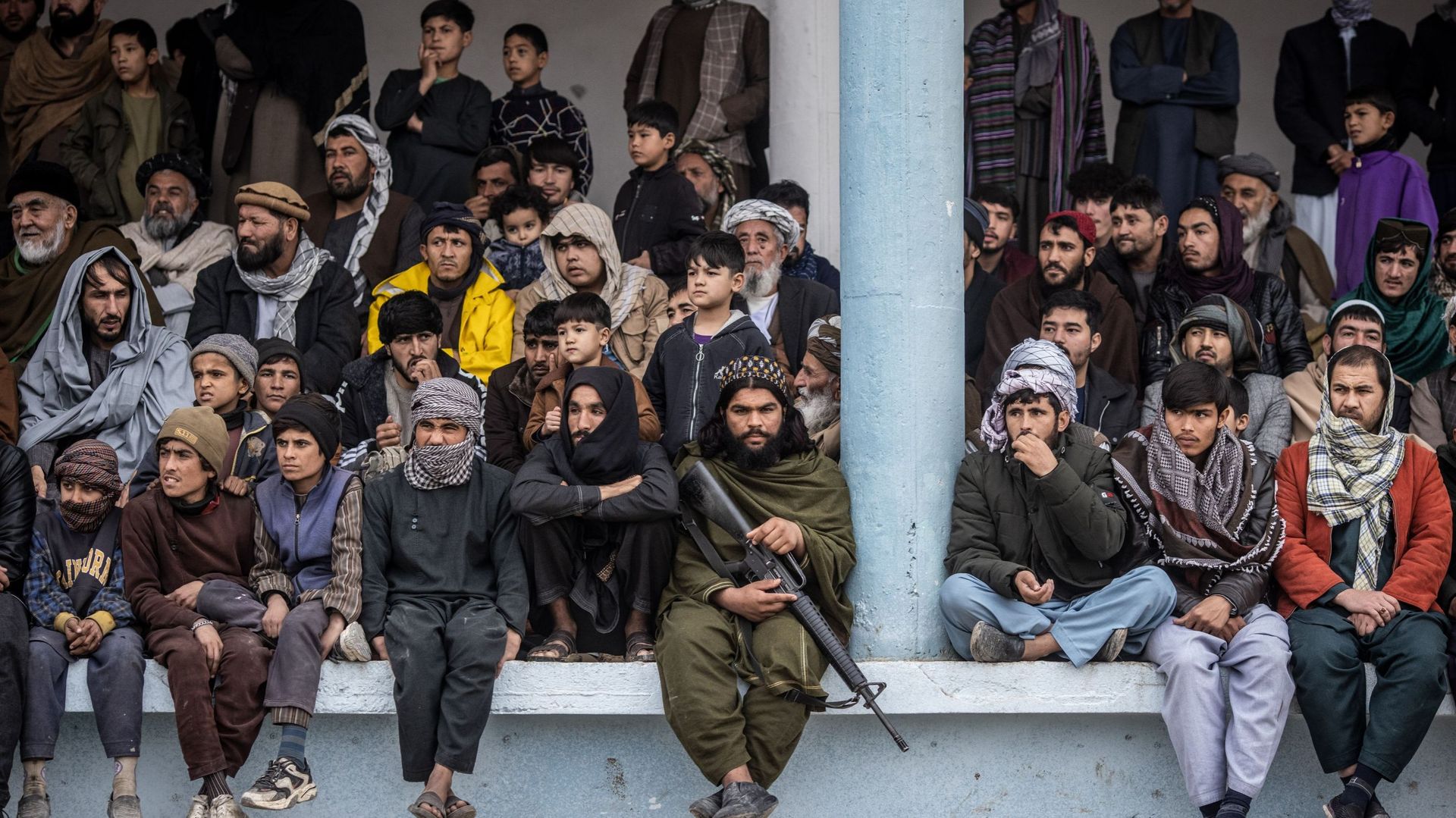 11 novembre 2022, Afghanistan, Mazar-E-Sharif : un membre des Talibans armé d'un fusil d'assaut M-16 est assis parmi les spectateurs d'une partie de buzkashi. Le buzkashi est un sport traditionnel d'Asie centrale dans lequel des joueurs à cheval tentent d