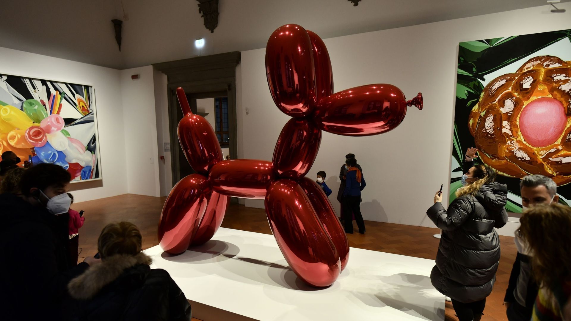 Des personnes regardent les œuvres d’art de Jeff Koons pendant l’exposition d’art "Shine" Jeff Koons au Palazzo Strozzi le 2 janvier 2022 à Florence, en Italie.