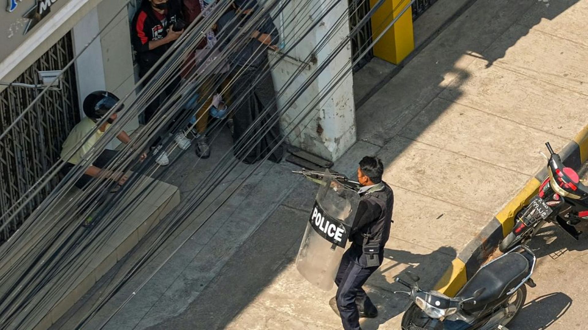 Un policier pointe son arme vers des manifestants à Taunggyi (Birmanie) le 28 février 2021
