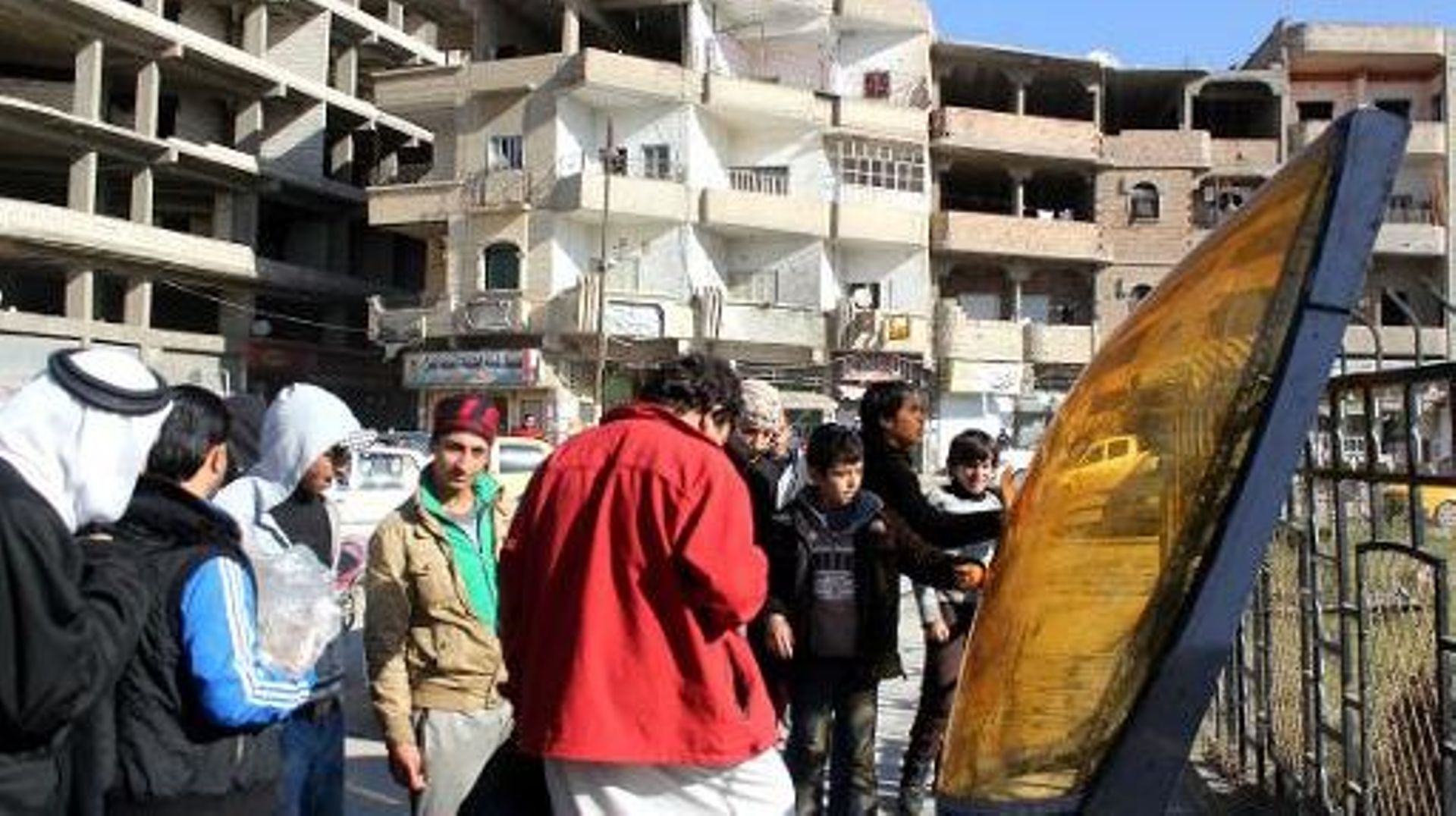 Une image du 24 décembre 2014 montrant des Syriens observant les débris d'un avion jordanien qui s'est écrasé dans la région de Raqa