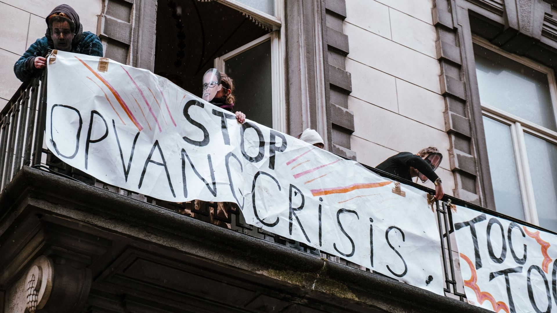 Des réfugiés et des manifestants en action au balcon du bâtiment nouvellement occupé, au numéro 91 de la rue de la Loi, à Bruxelles, le dimanche 23 avril 2023. 