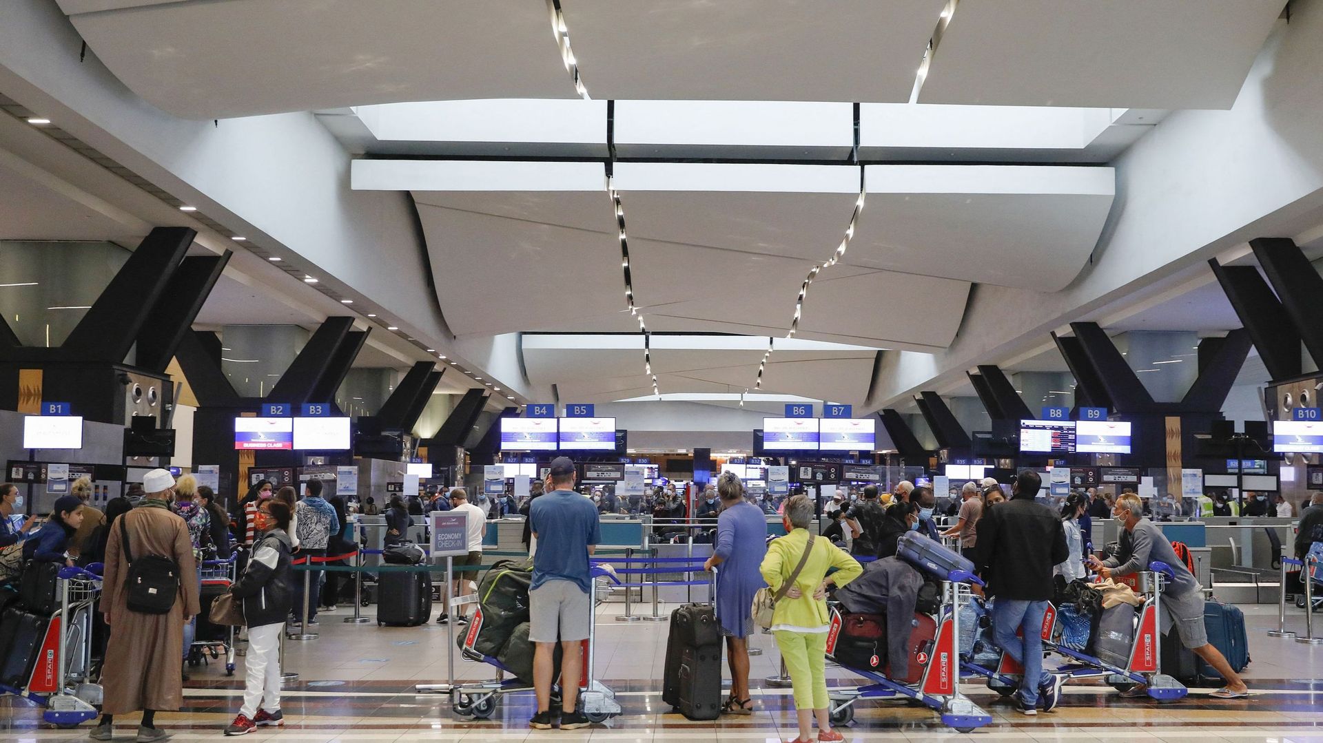 Des voyageurs font la queue à l’aéroport de Johannesburg le 27 novembre 2021, après que plusieurs pays ont interdit les vols en provenance d’Afrique du Sud à la suite de la découverte du variant Omicron