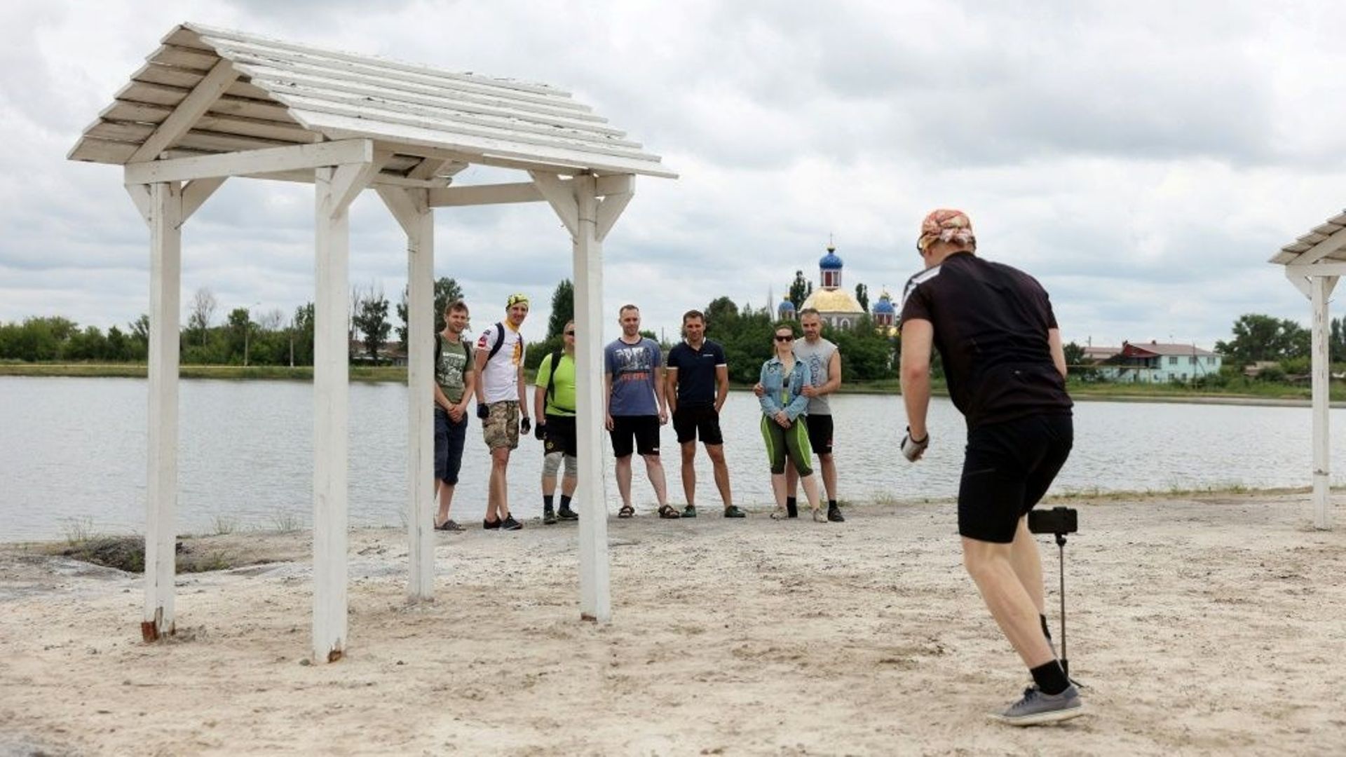 Des cyclistes font une photo de groupe sur la plage de Sloviansk, dans l'est de l'Ukraine, le 22 juin 2022.