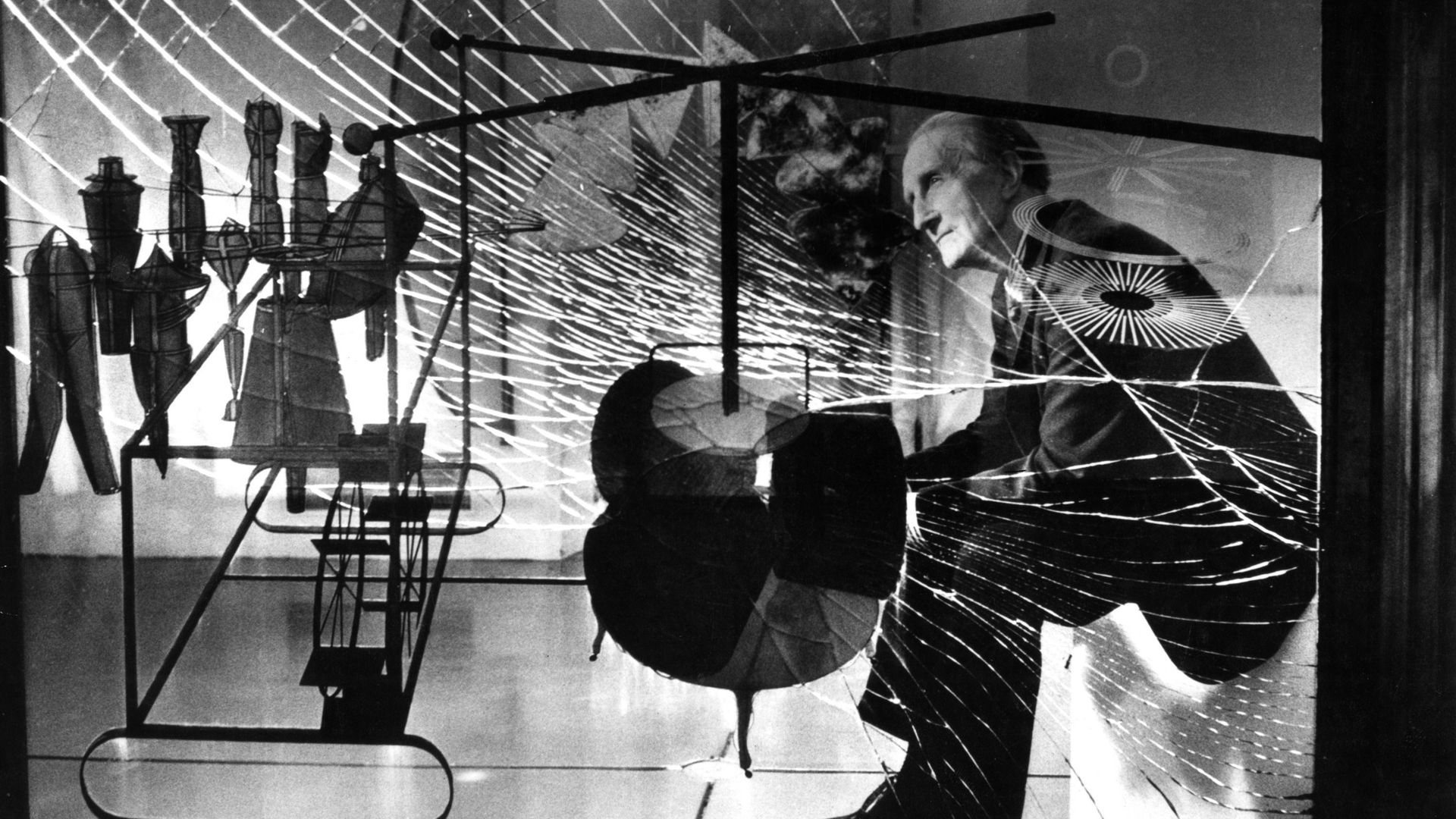 L’artiste Marcel Duchamp regarde à travers une vitre l’une de ses œuvres majeures "La Mariée mise à nue par ses célibataires même".