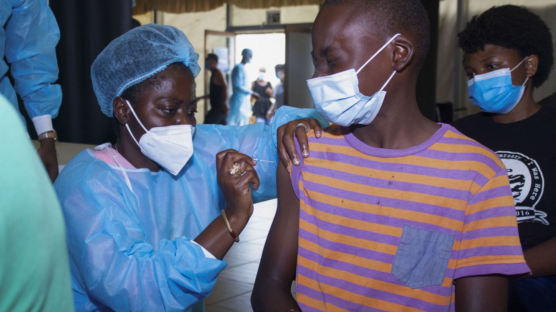 Une infirmière (G) administre une dose du vaccin Pfizer/BioNTech contre le Covid-19 à un adolescent lors de l’événement Cultural Paz Flor à Luanda en Angola, le 16 décembre 2021. Osvaldo Silva / AFP