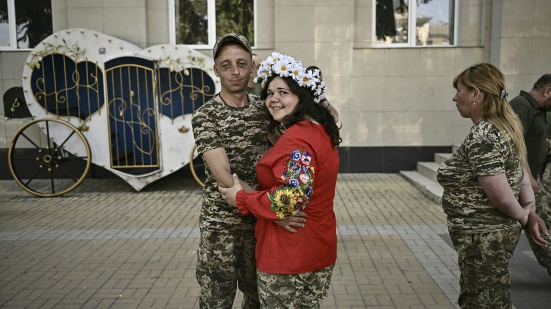 Les militaires ukrainiens Kristina Liouta (à droite) et Volodymyr Mykhalchouk durant leur mariage dans la ville de Droujkivka, dans l’est de l’Ukraine, le 12 juin 2022