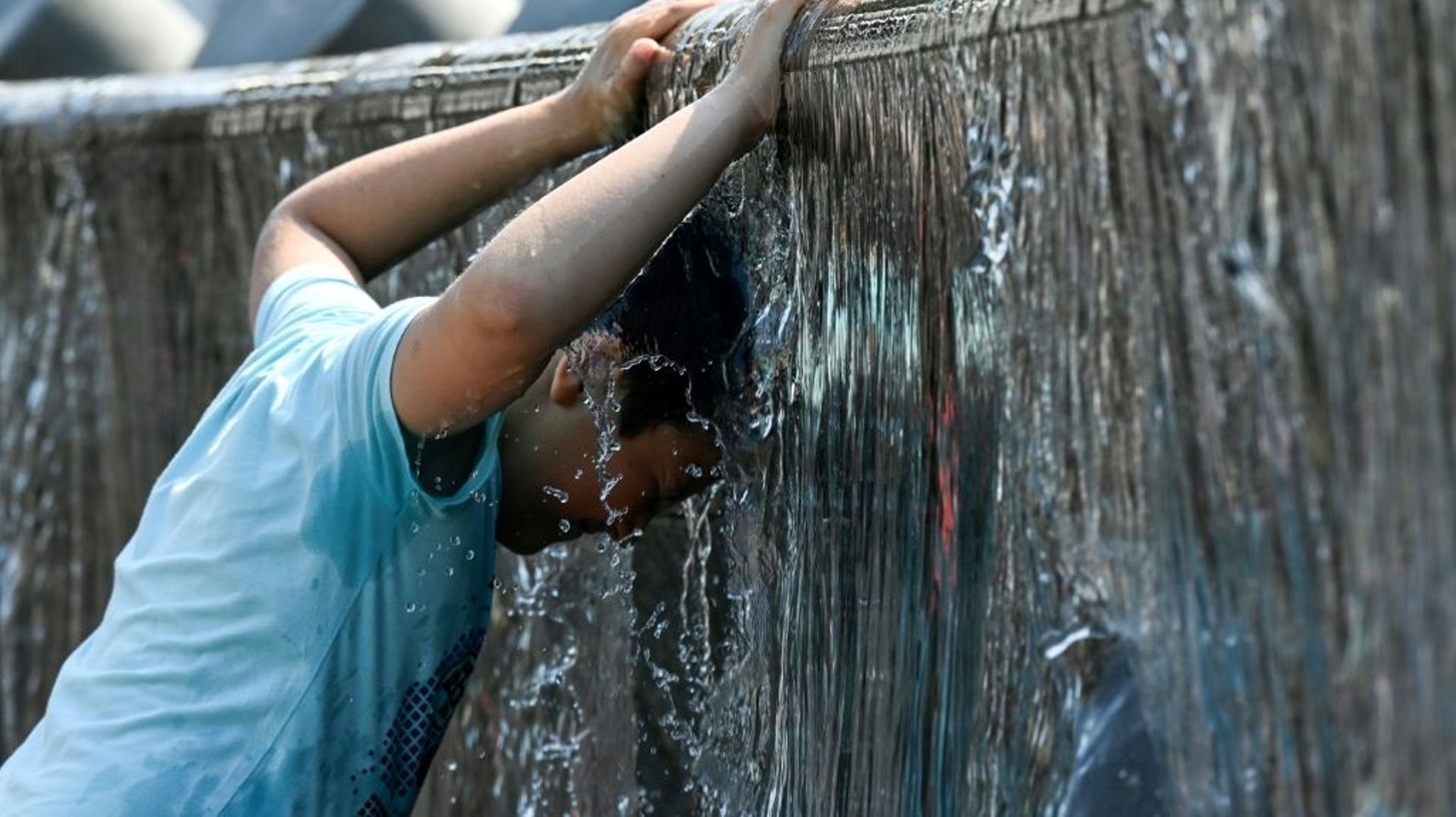 Un enfant se rafraîchissant dans une fontaine en juillet 2021 à Moscou