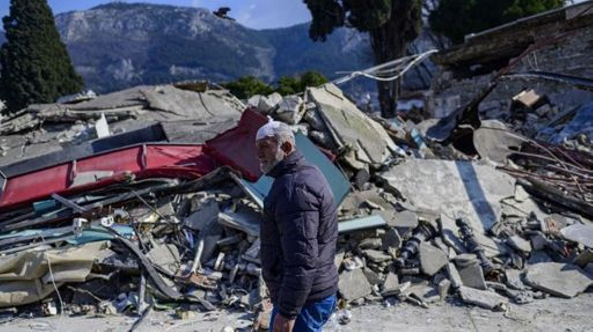 An injured local resident walks past rubbles in Hatay, on February 11, 2023, after a 7.8-magnitude earthquake struck the country’s southeast. Rescuers pulled out children on February 10, 2023, from the rubble of the Turkey-Syria earthquake that struck on