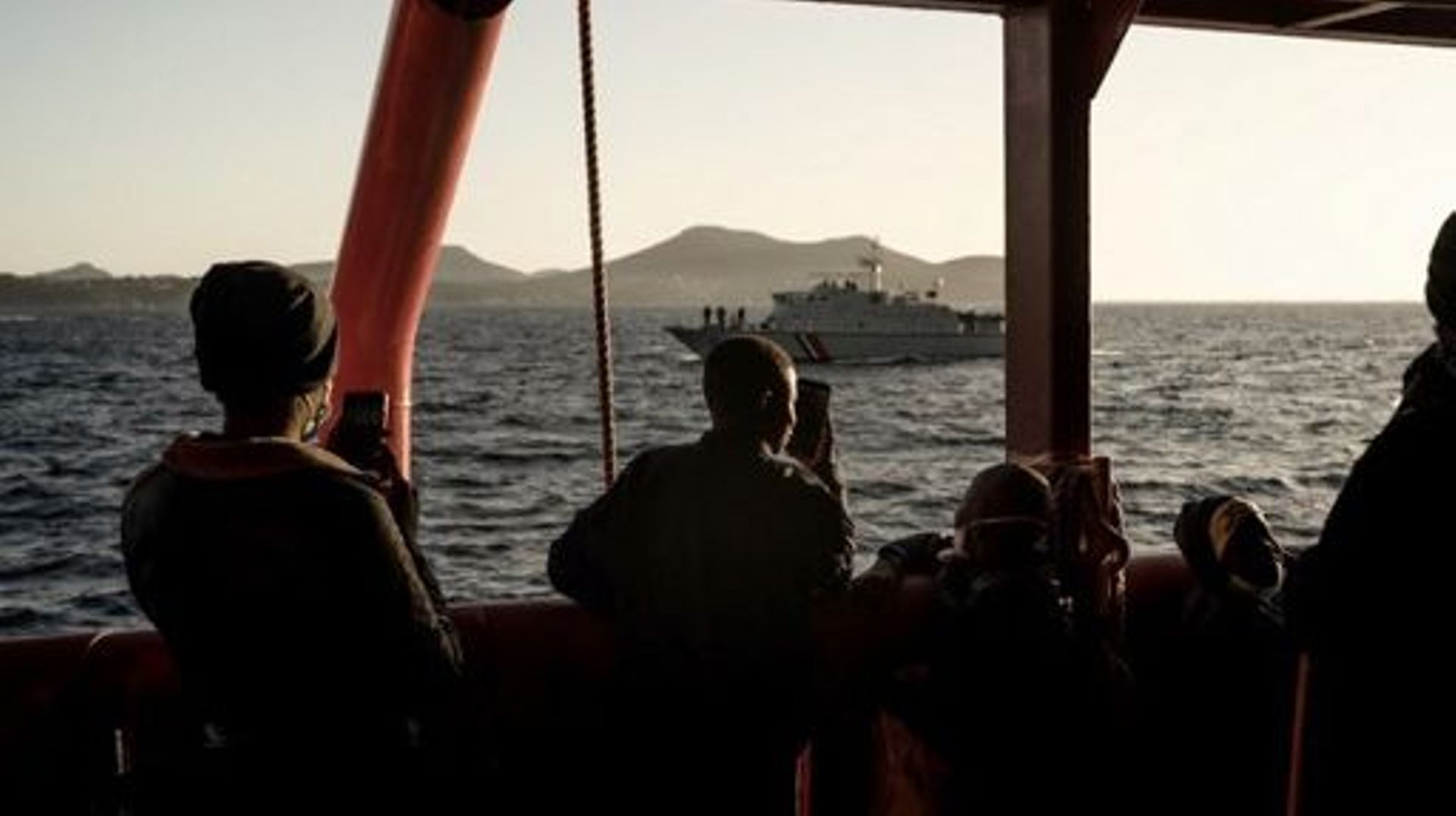 Migrants stand on board the Ocean Viking prior disembarking in Toulon on November 11, 2022, after being rescued by European maritime-humanitarian organization "SOS Mediterranee".  Migrant rescue group SOS Mediterranee said on November 3, 2022 it had calle