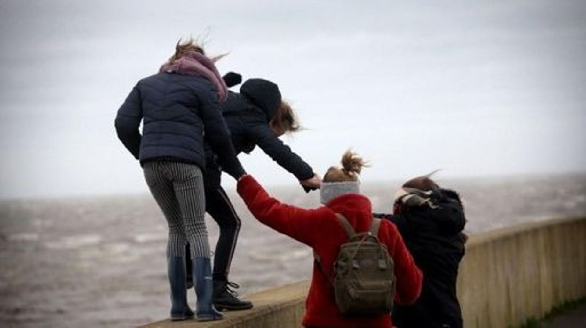 People walk on a bulwark against strong wind during the storm Ciara in Harlingen, The Netherlands, on February 9, 2020.  With howling winds and driving rain, forecasters said Ciara would also hit France, Belgium, the Netherlands, Switzerland and Germany. 