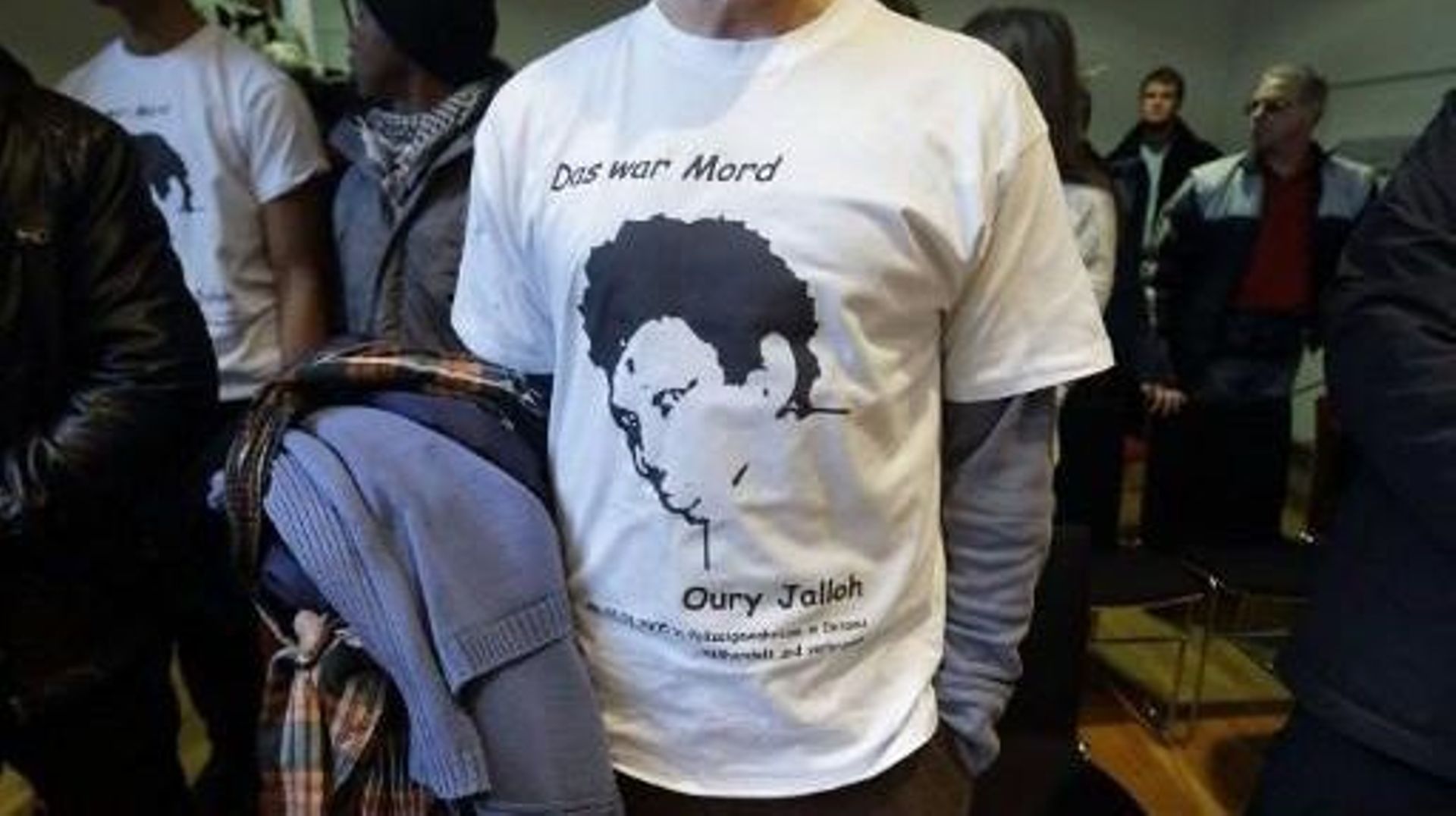 Un homme portant un t-shirt à l'effigie d'Oury Jalloh, un demandeur d'asile de la Sierra Leone, assiste au procès de l'officier de police Andreas S., accusé d'être impliqué dans la mort de Jalloh, au tribunal régional de Magdebourg, dans l'est de l'Allema