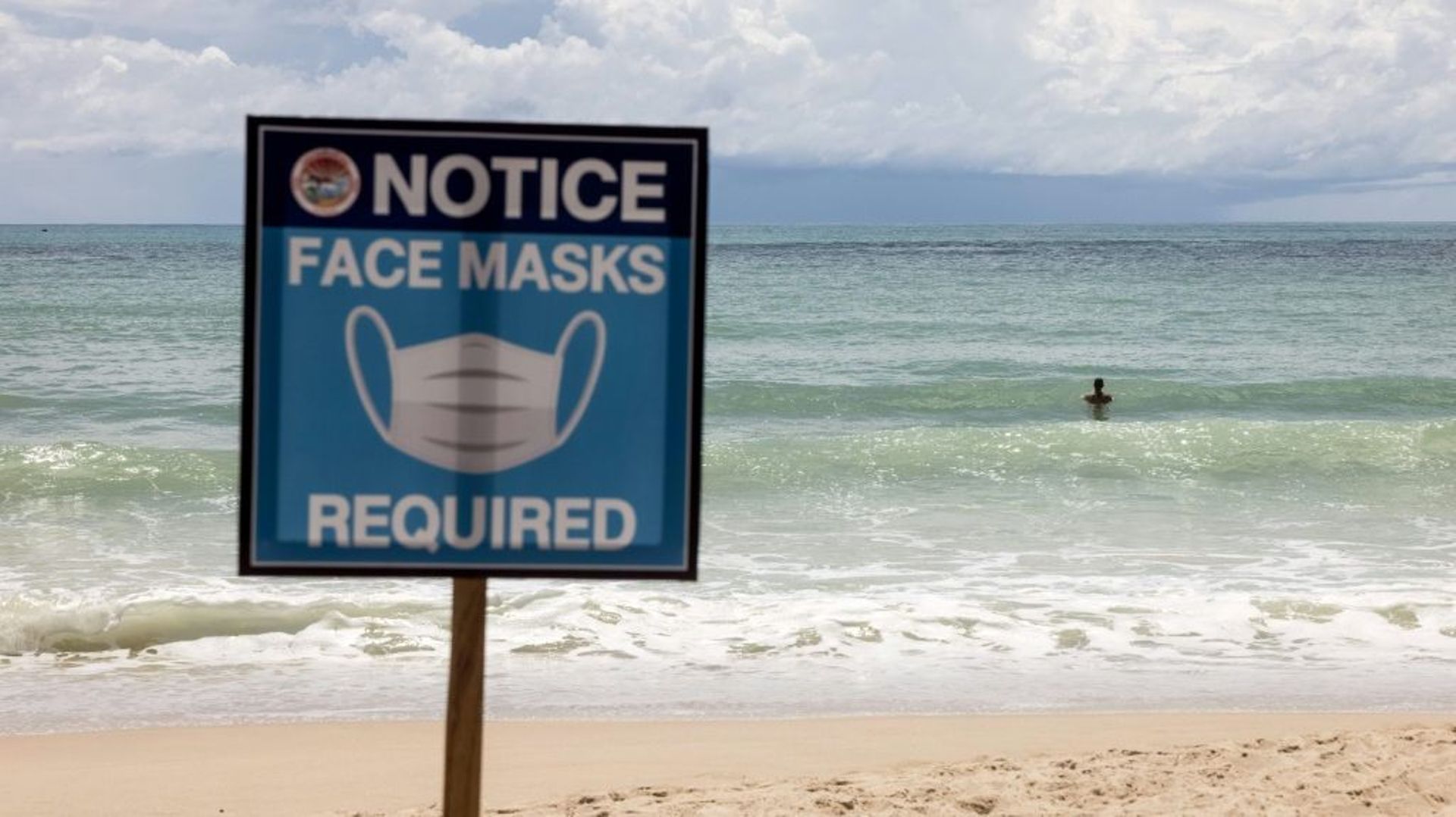 Cette photo d'illustration prise le 14 août 2021 montre un panneau indiquant "Masques obligatoires" sur la plage de Patong à Phuket