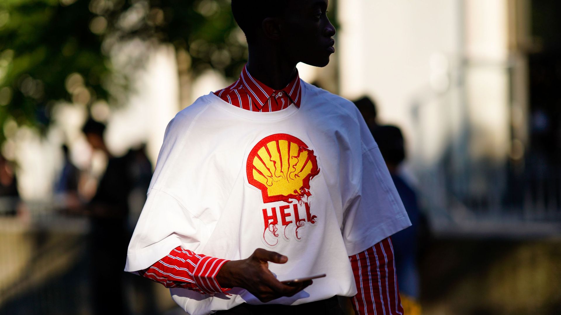 Une invitée portant un t-shirt blanc avec le logo Shell et le mot "hell" pendant la Fashion Week de Paris en juin 2018 à Paris (illustration)