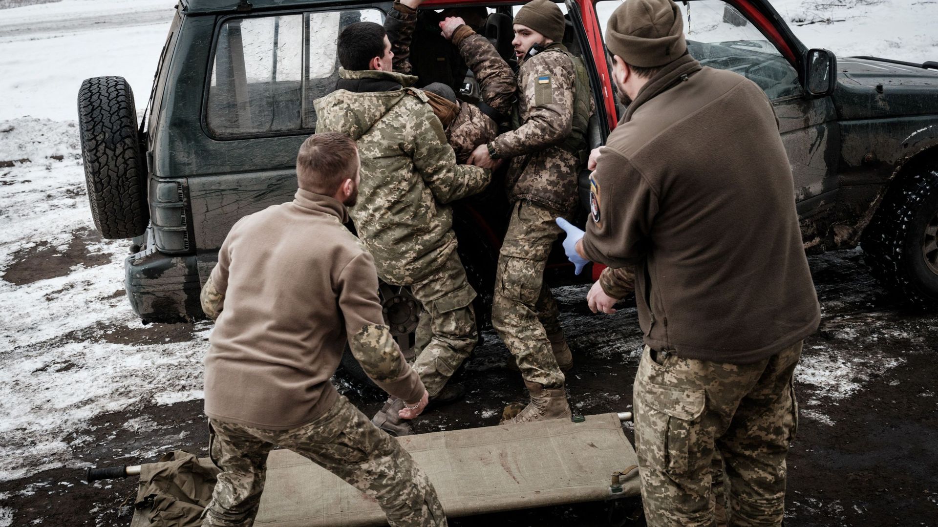 Des ambulanciers reçoivent un militaire ukrainien blessé qui a marché sur une mine terrestre antipersonnel à un point de stabilisation pour un traitement d’urgence, près de la ligne de front dans la région de Donetsk, le 29 janvier 2023, en pleine invasio