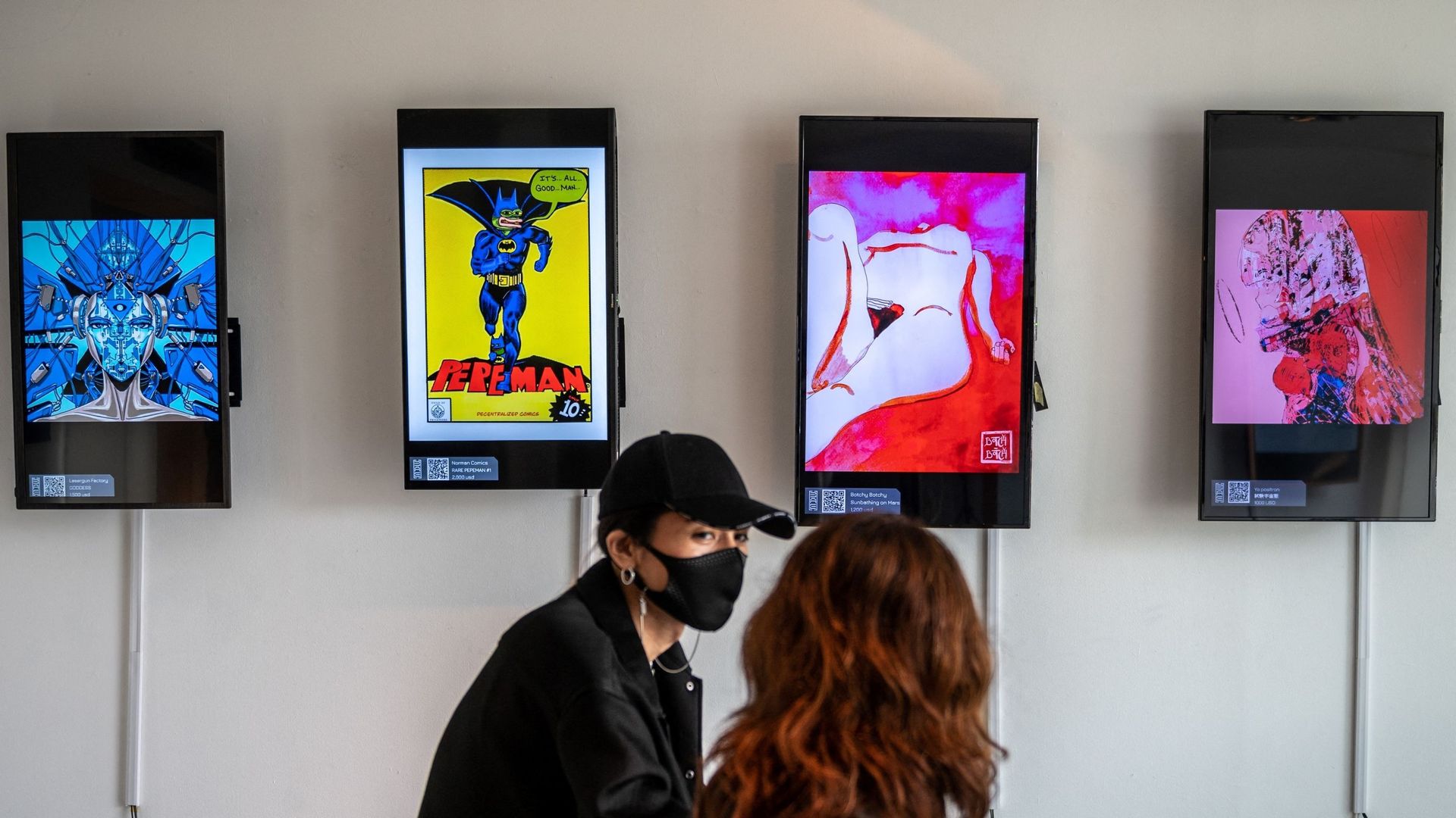 Cette photo prise le 25 juin 2021 montre des personnes visitant "CrypTOKYO", une exposition d'art physique sur la blockchain à Tokyo. Quelque 150 jetons non fongibles (NFT) de plusieurs dizaines d'artistes étaient exposés à l'exposition "CrypTokyo" dans l