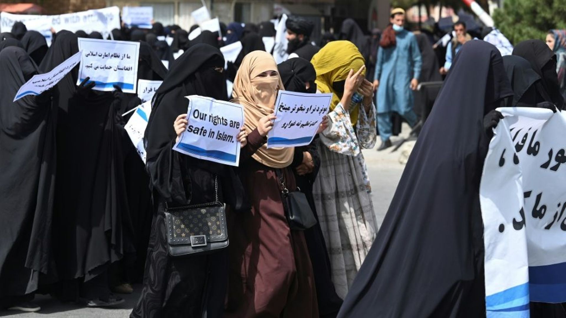 Des Afghanes en niqabs noirs défilent avec des pancartes pro-talibans devant l’université Shaheed Rabbani, le 11 septembre 2021 à Kaboul