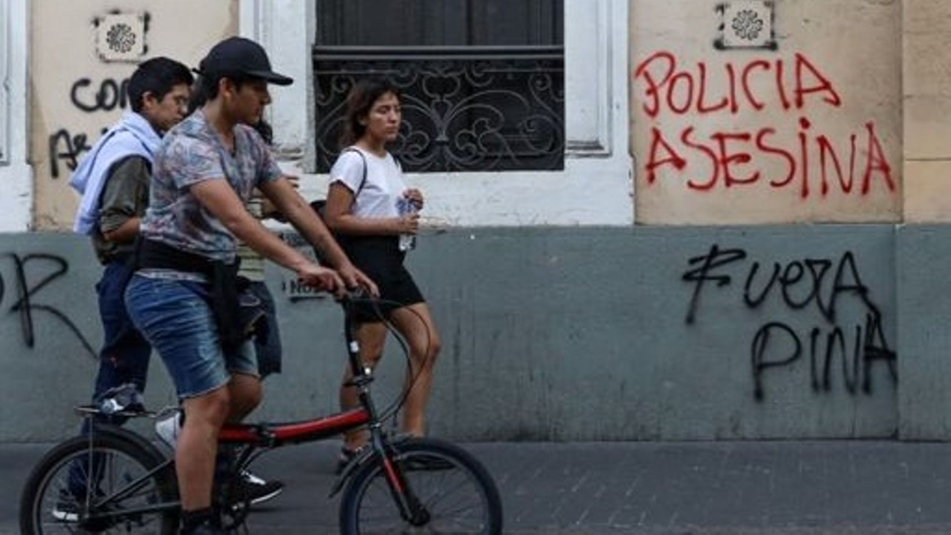 Des personnes passent devant un graffiti indiquant "Police meurtrière, Dina dehors" à Lima, le 18 décembre 2022. Le secrétaire d'État américain Antony Blinken s'est entretenu avec la présidente péruvienne Dina Boluarte, qu'il a exhortée à poursuivre les r