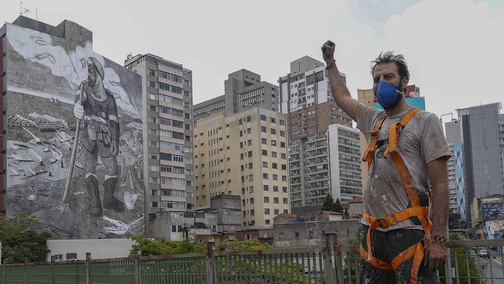 L’artiste brésilien Mundano pose avec sa fresque de 780m², peinte avec des cendres ramassées lors d’incendies de forêt, qui réinterprète l’œuvre "O lavrador de cafe" du peintre brésilien Candido Portinari, à Sao Paulo, le 13 octobre 2021.