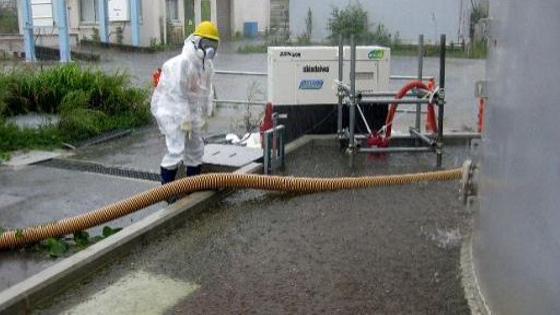 Sur cette photographie du 15 septembre 2013, distribuée par Tepco, le 17 septembre, un employé de l'entreprise pompe l'eau de pluie accumulée à proximité des installations de la centrale nucléaire de Fukushima