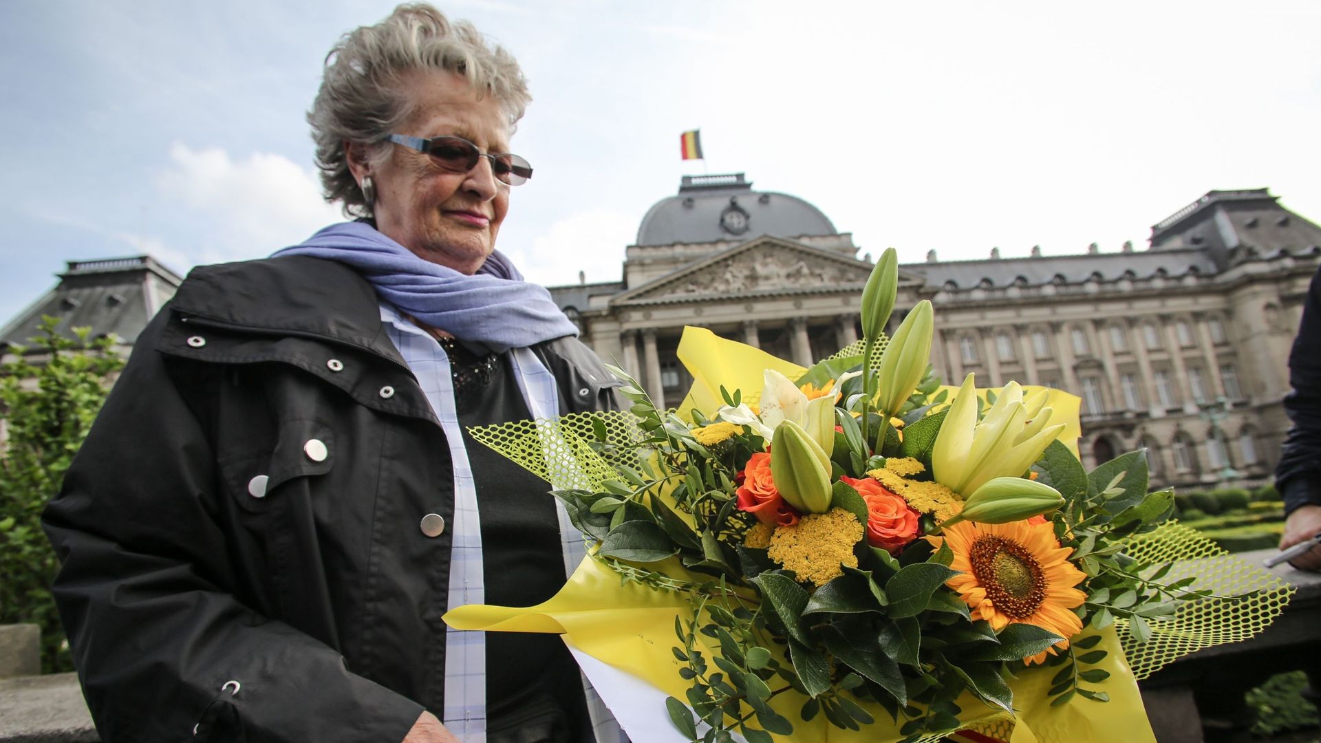 Une femme dépose des fleurs en hommage au roi Albert II