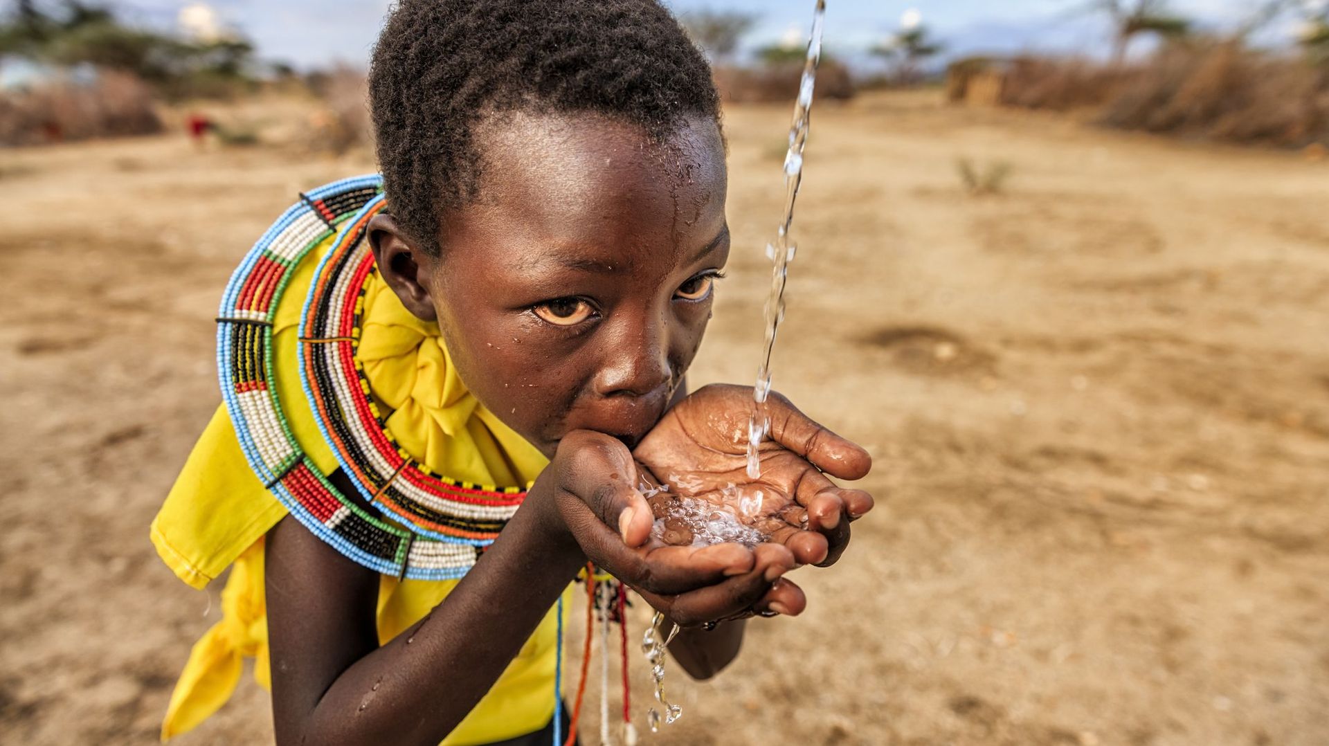 African girl from Samburu tribe drinking fresh water, East Africa