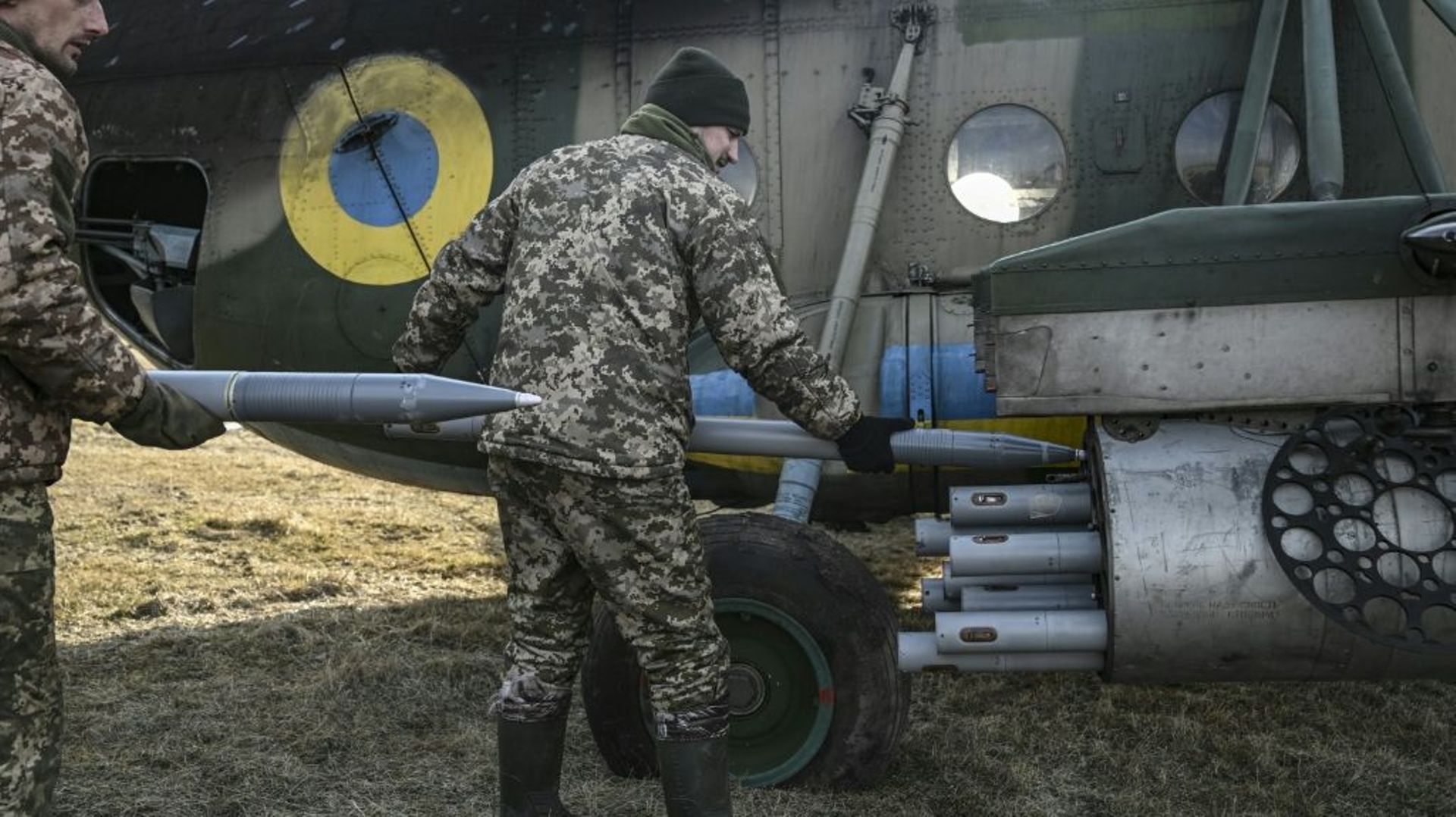Des militaires ukrainiens chargent des roquettes sur un hélicoptère Mil MI-8, le 10 mars 2023 dans l’est de l’Ukraine