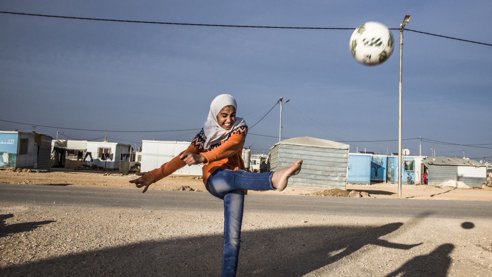 Tous les matins, dans le camp de réfugiés syriens de Zaatari, des dizaines de fillettes foulent le terrain à l’abri des regards et de la pression de la communauté. Avec ceci de supplémentaire qu’ici, le football casse le rythme du camp et éloigne autant q