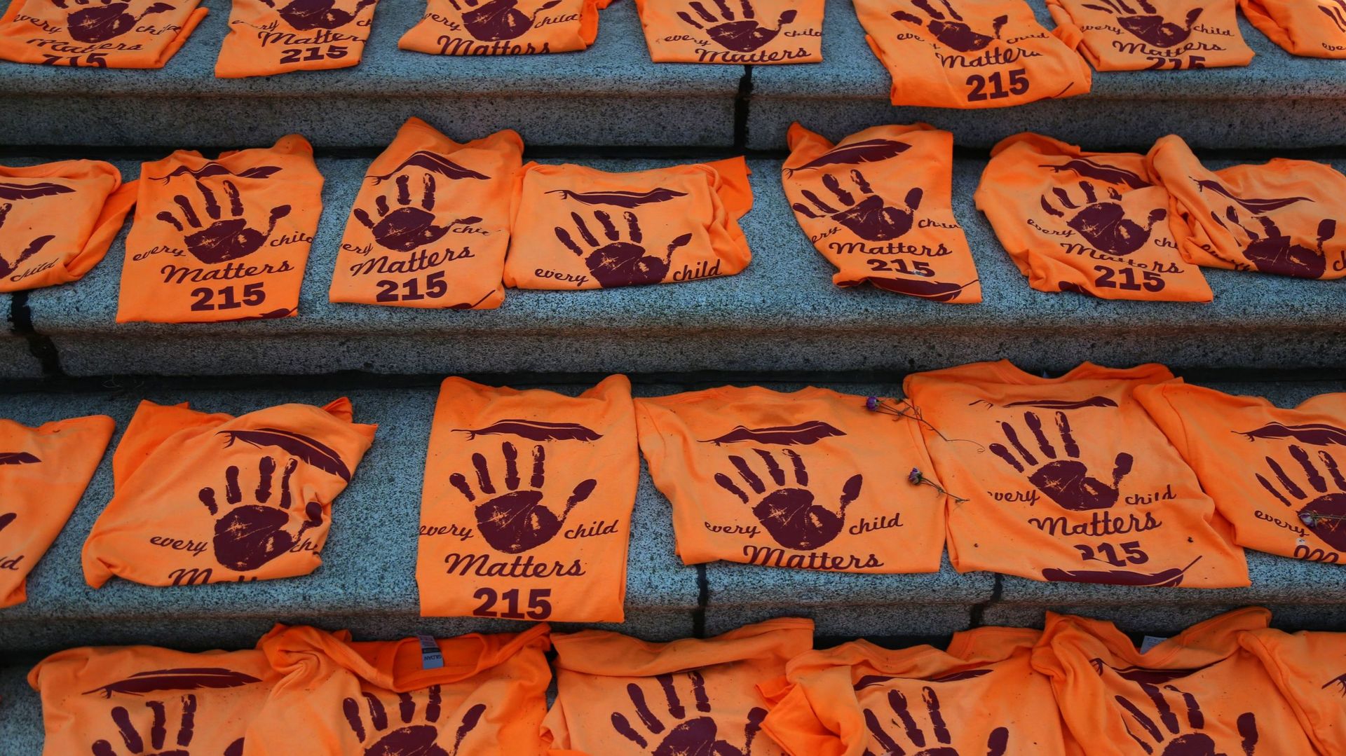 Des t-shirts orange placés pour honorer les enfants autochtones enterrés au pensionnat de Kamloops à l'extérieur de l'édifice du Parlement de la Colombie-Britannique à Victoria, Canada.