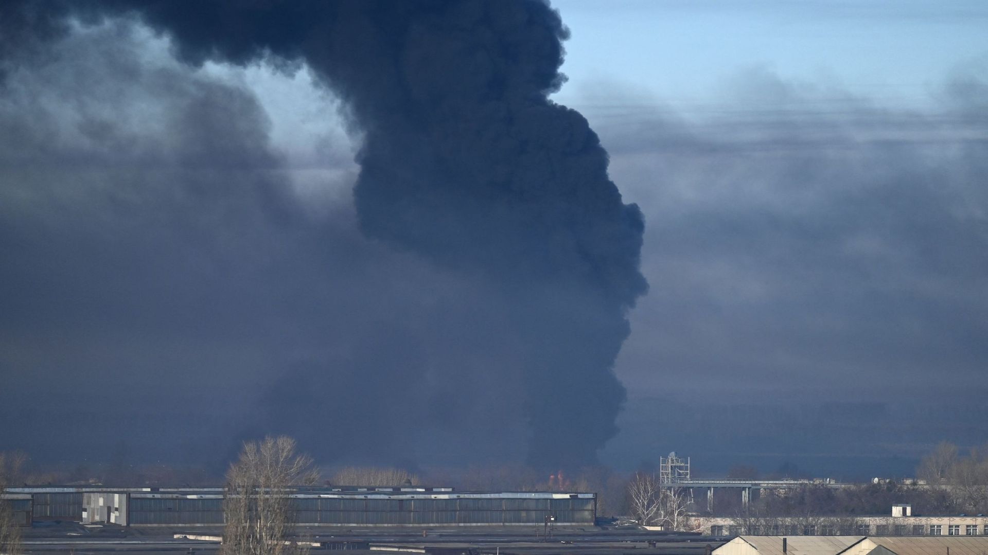 De la fumée noire s’élève d’un aéroport militaire à Chuguyev, près de Kharkiv, le 24 février 2022.
