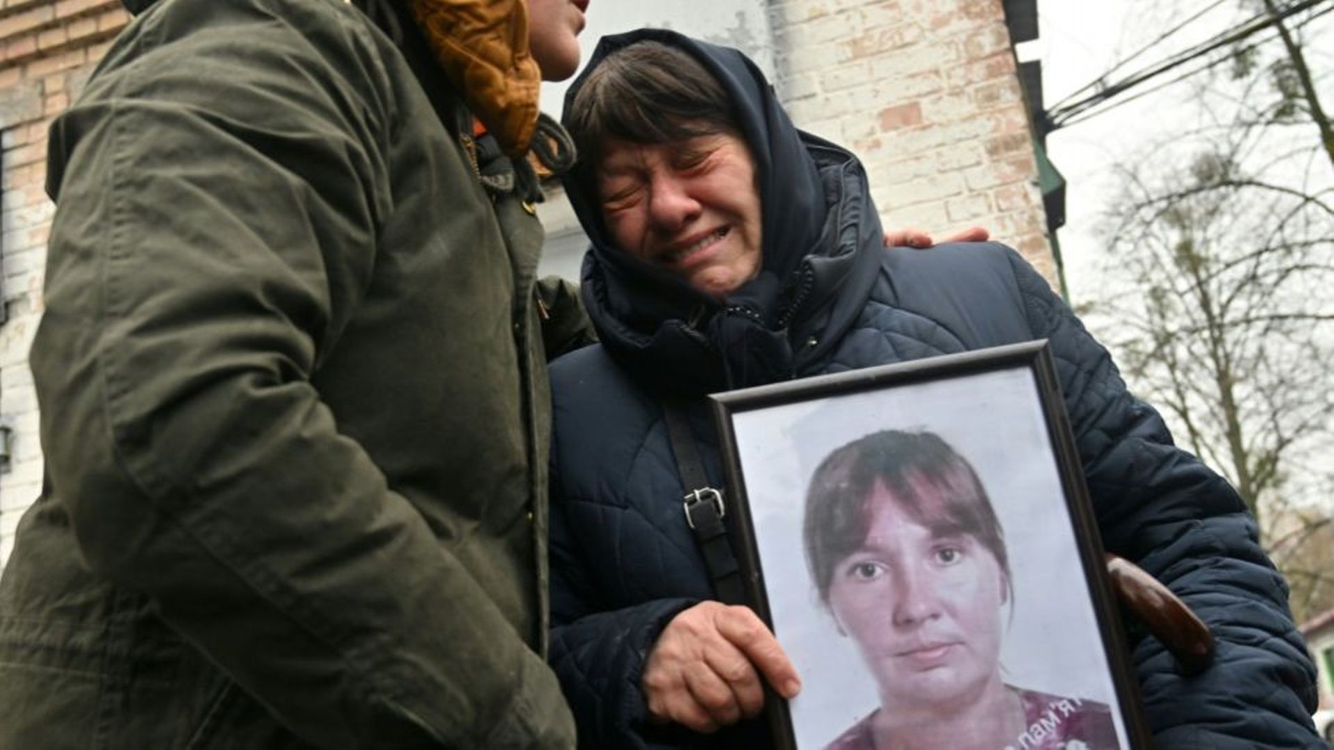 En larmes, Nadia Kovalenko (à droite) tient une photo de sa fille Inna, qui a été tuée le mois dernier à Boutcha (Ukraine), le 22 avril 2022 à Boutcha
