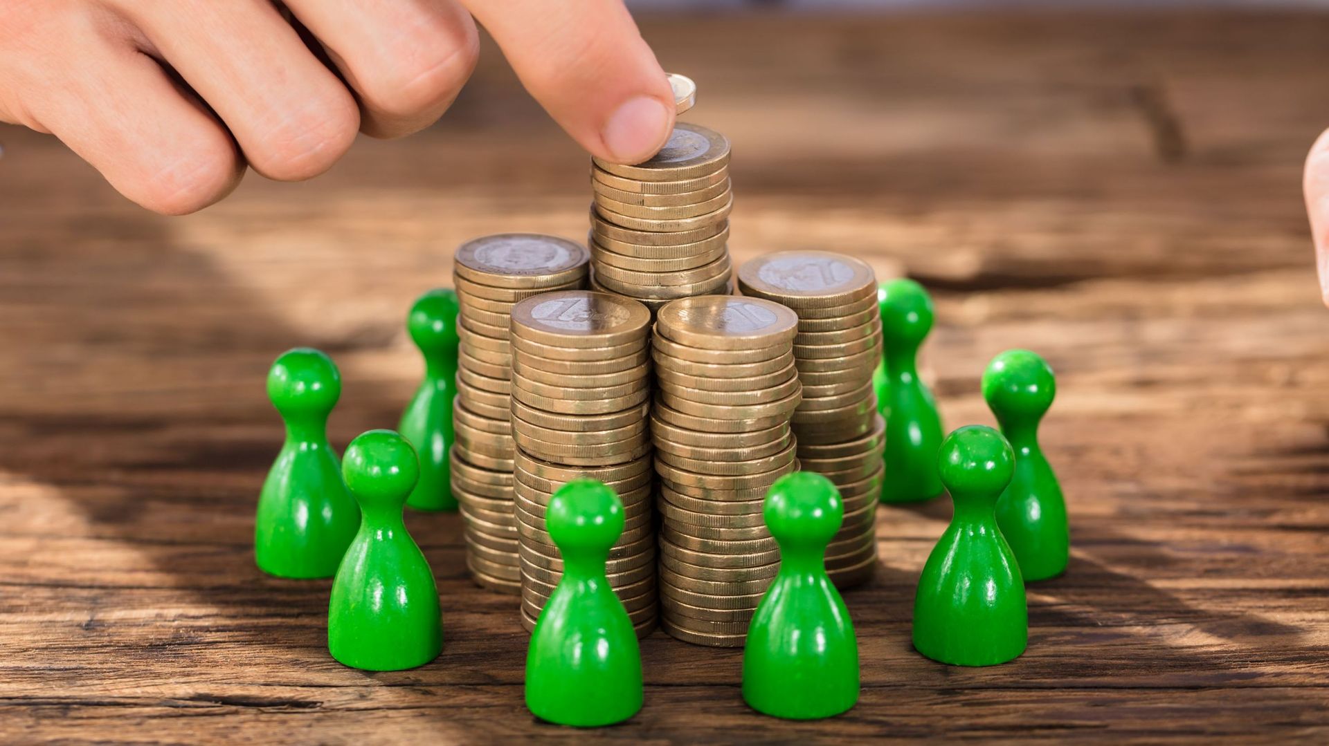 Businessman Placing Coins Over Stack With Green Figures.