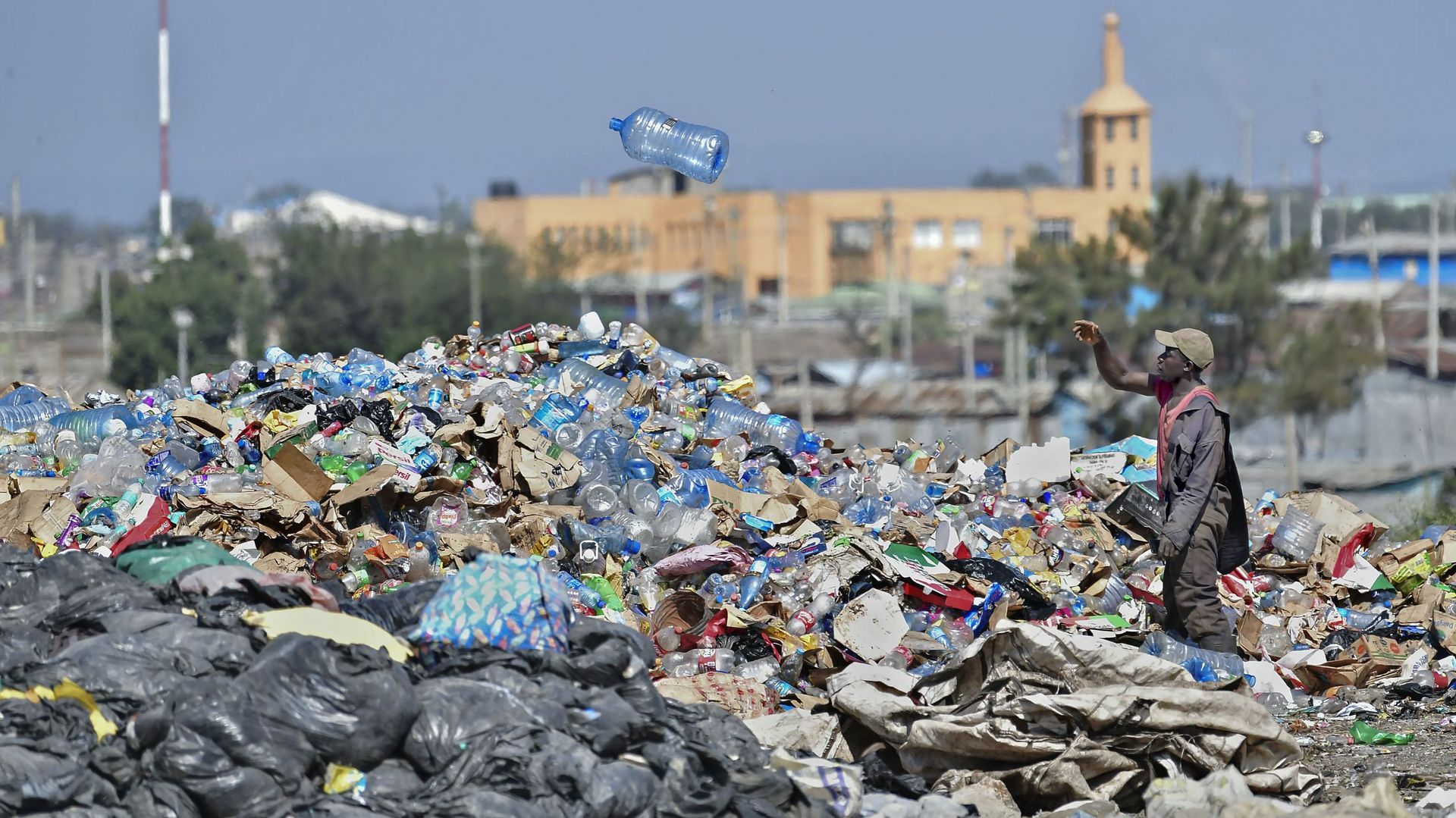 Un récupérateur de déchets trie les bouteilles en plastique à la décharge de Dandora, au Kenya.
