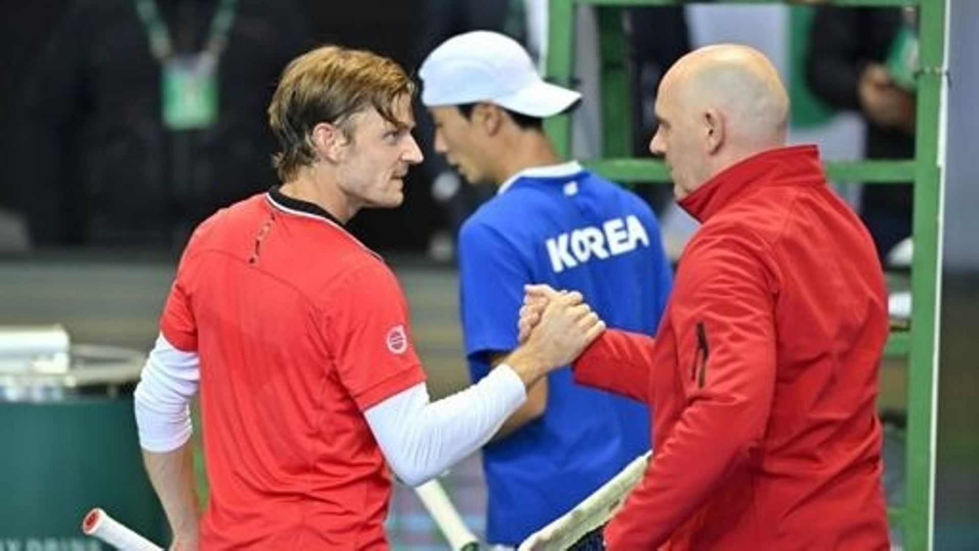Belgium's David Goffin (L) celebrates with team captain Johan Van Herck (R) after defeating South Korea's Hong Seong-chan (C) during their singles match of the Davis Cup qualifiers first round between South Korea and Belgium in Seoul on February 4, 2023. 