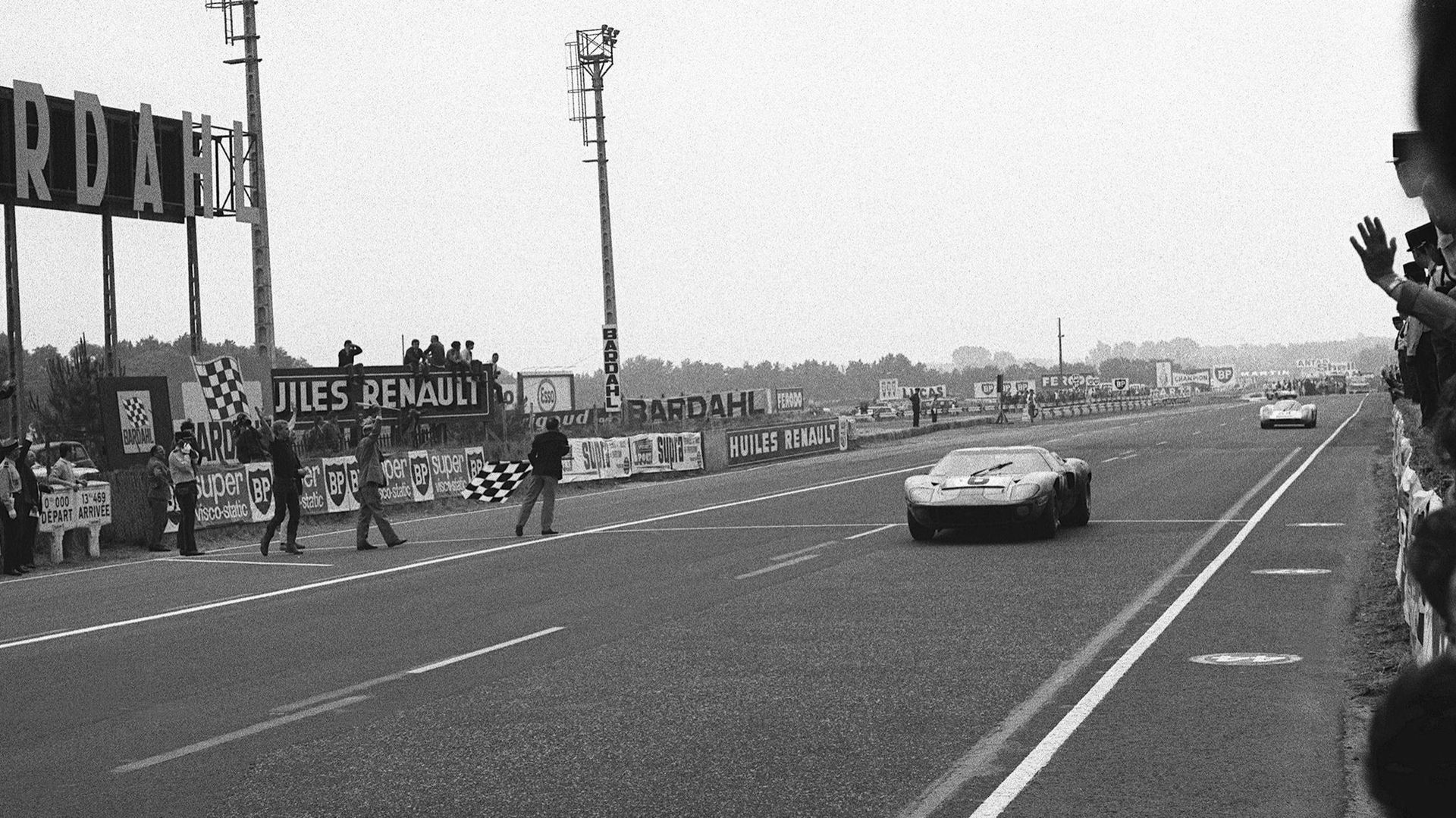 La Ford GT 40 pilotée par Jacky Ickx passe la ligne d’arrivée, quelques centièmes de secondes avant la Porsche 908 de Hans Herrmann.