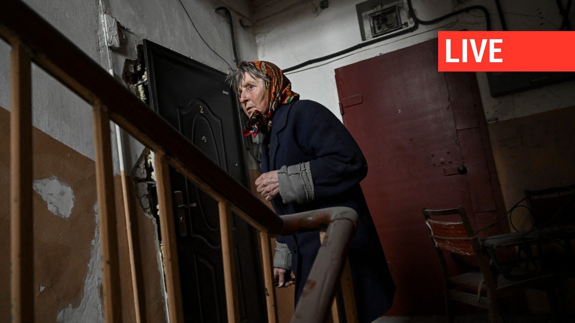 Une femme se tient dans un bâtiment résidentiel après un bombardement dans le village de Chasiv Yar, le 11 mars 2023.