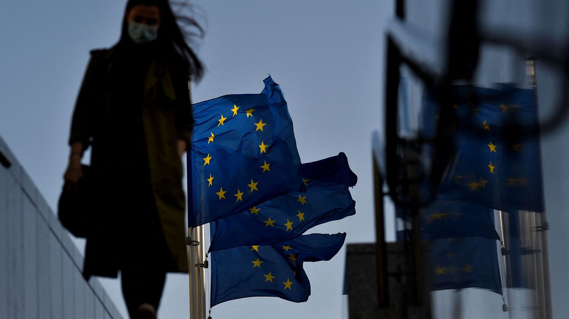 Passante masquée près des drapeaux européens à Bruxelles, le 23 février 2021 (illustration)