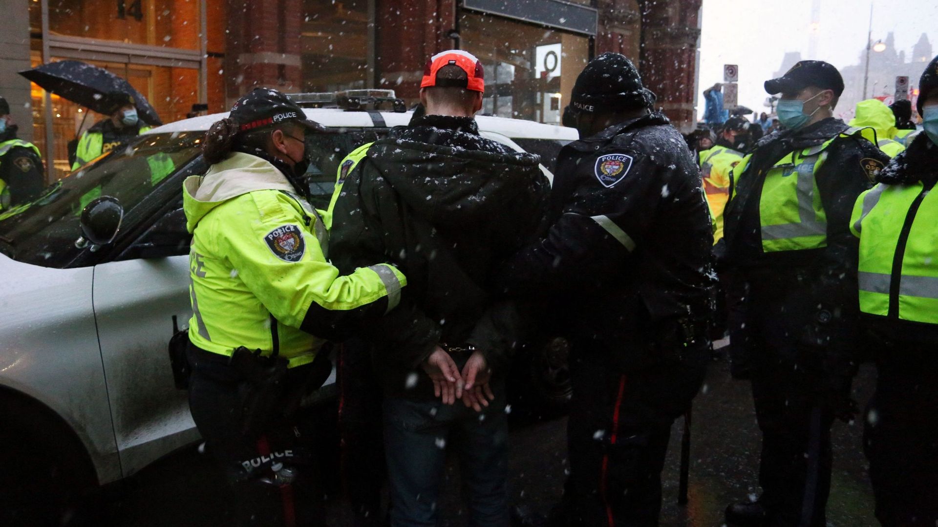 Des policiers escortent un manifestant arrêté jusqu'à une voiture de police lors d'une manifestation sur les règles de santé en cas de pandémie et le gouvernement Trudeau à Ottawa, au Canada, le 17 février 2022.